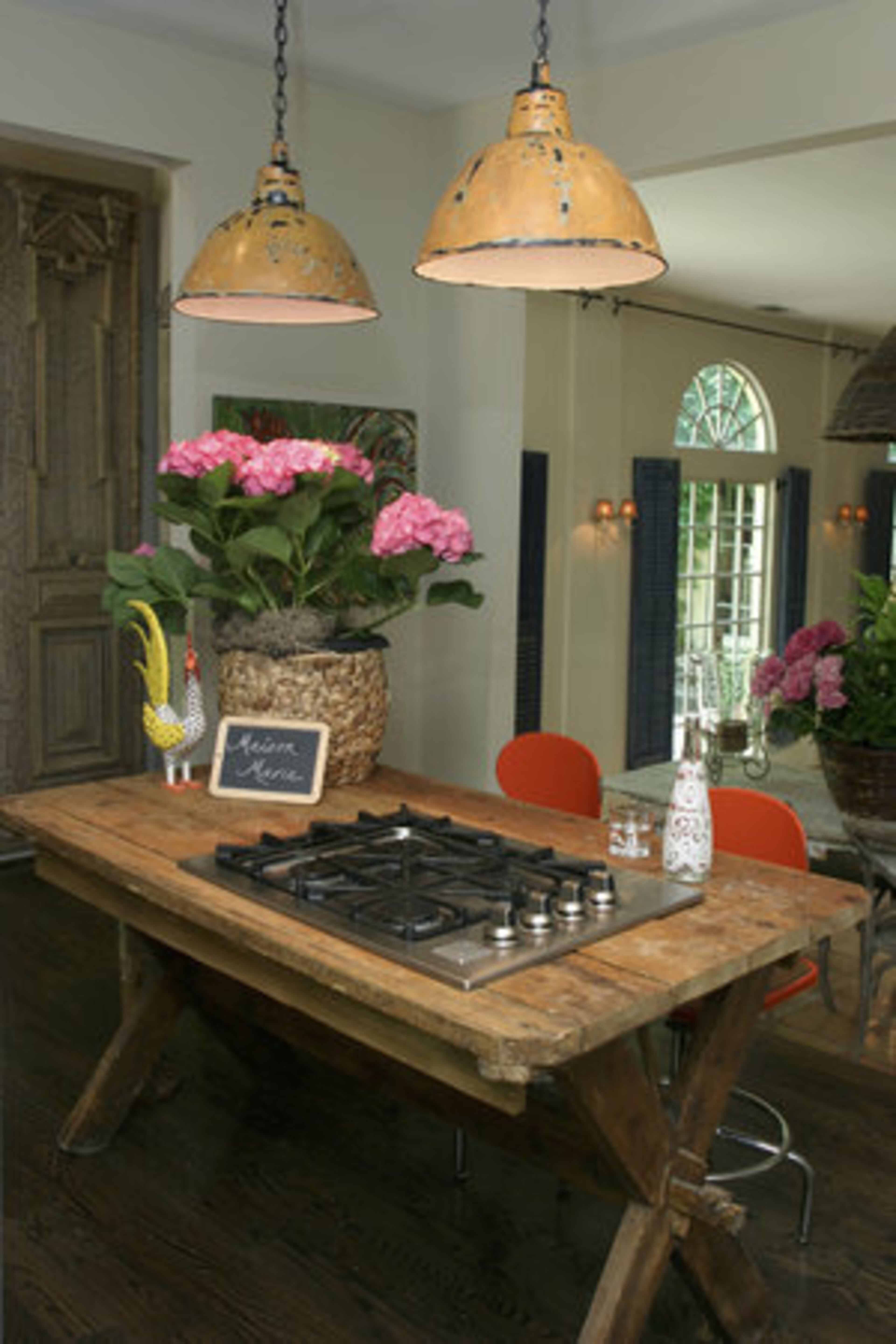 "I wanted the kitchen to be like a true Provence house, but they don't have islands, they have furniture," explains Mary. "I found this wonderful piece of furniture and had the stove dropped in, put an apron around it, and ran the electrical and gas through the floor up its leg, so when you look at it you really can't see how it's working." She says of her clever stove: "It feels very much in line with the style of the house." The light fixtures are old industrial lights sourced in France.