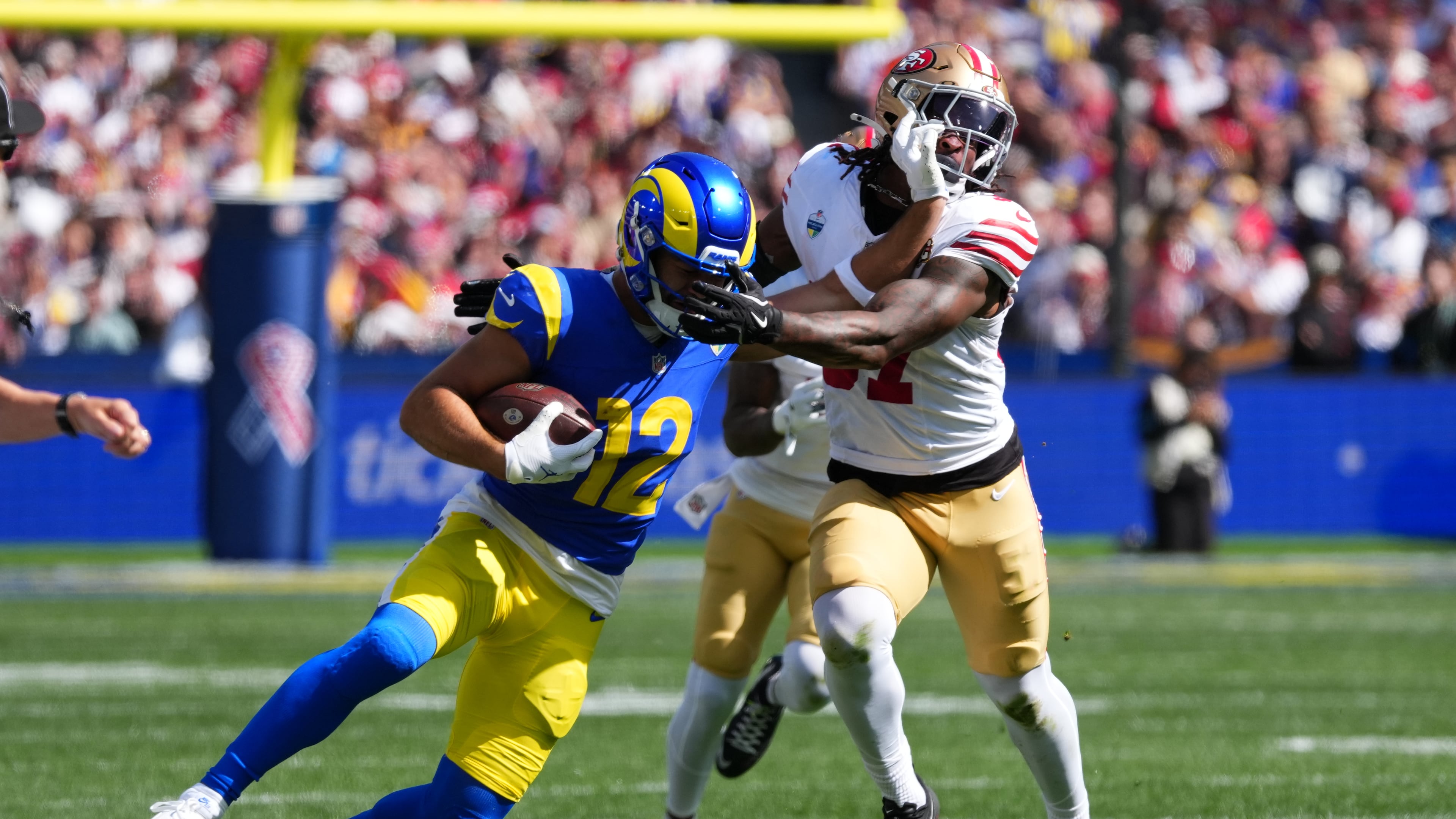 Los Angeles Rams wide receiver Puka Nacua runs pass San Francisco 49ers safety Ji'ayir Brown during the first half of an NFL football game, Friday, Sept. 11, 2026, in Melbourne, Australia. (AP Photo/Scott Barbour)