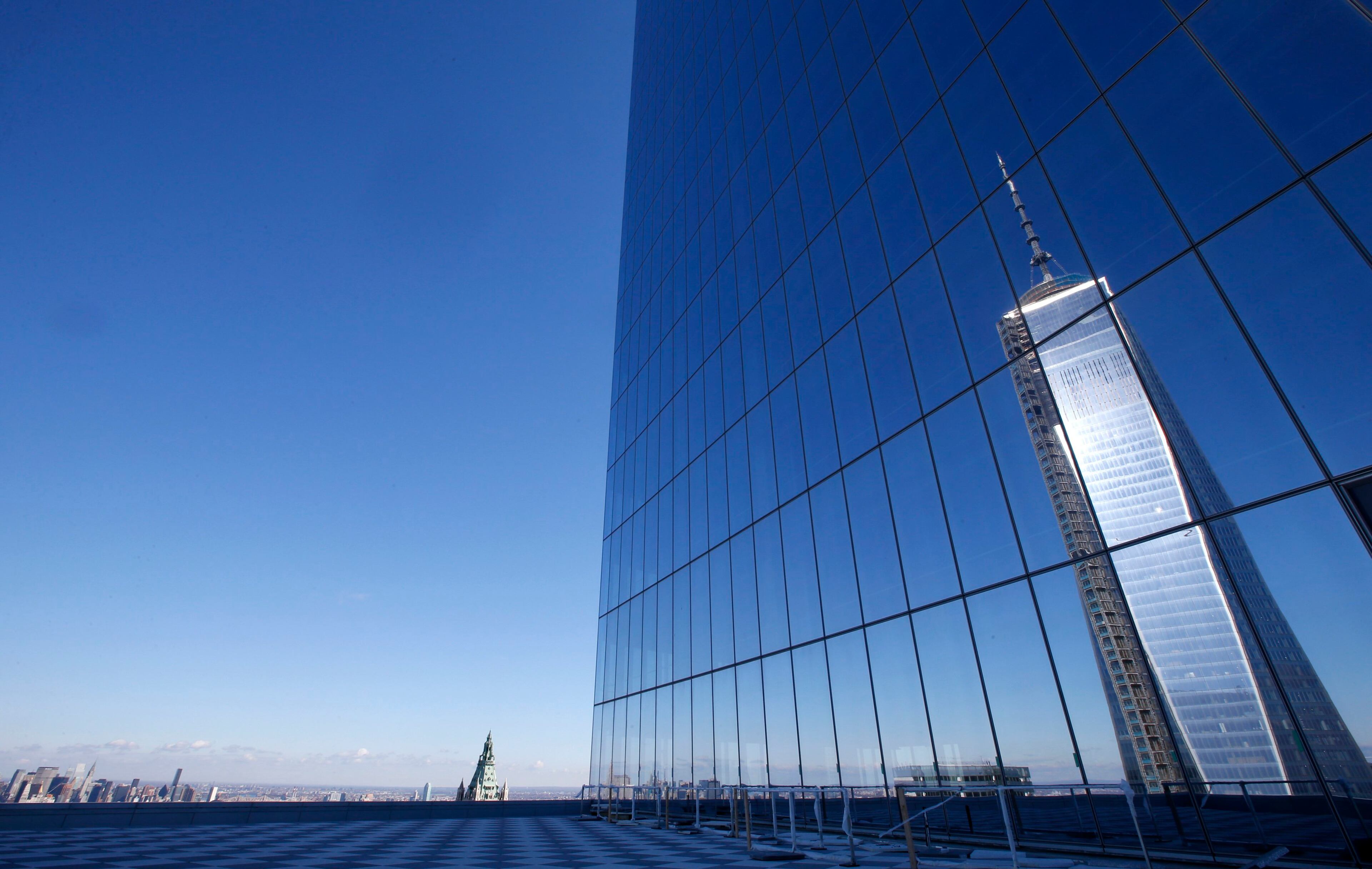 A reflection of the One World Trade Center tower is seen from a terrace on the 57th floor of the soon to be opened 4 World Trade Center tower in New York, November 8, 2013. 4 World Trade center sits at the south east corner of the World Trade Center site and will be the second tower to open on the site since the 2001 attacks on the World Trade Center. REUTERS/Mike Segar (UNITED STATES - Tags: BUSINESS CITYSCAPE)