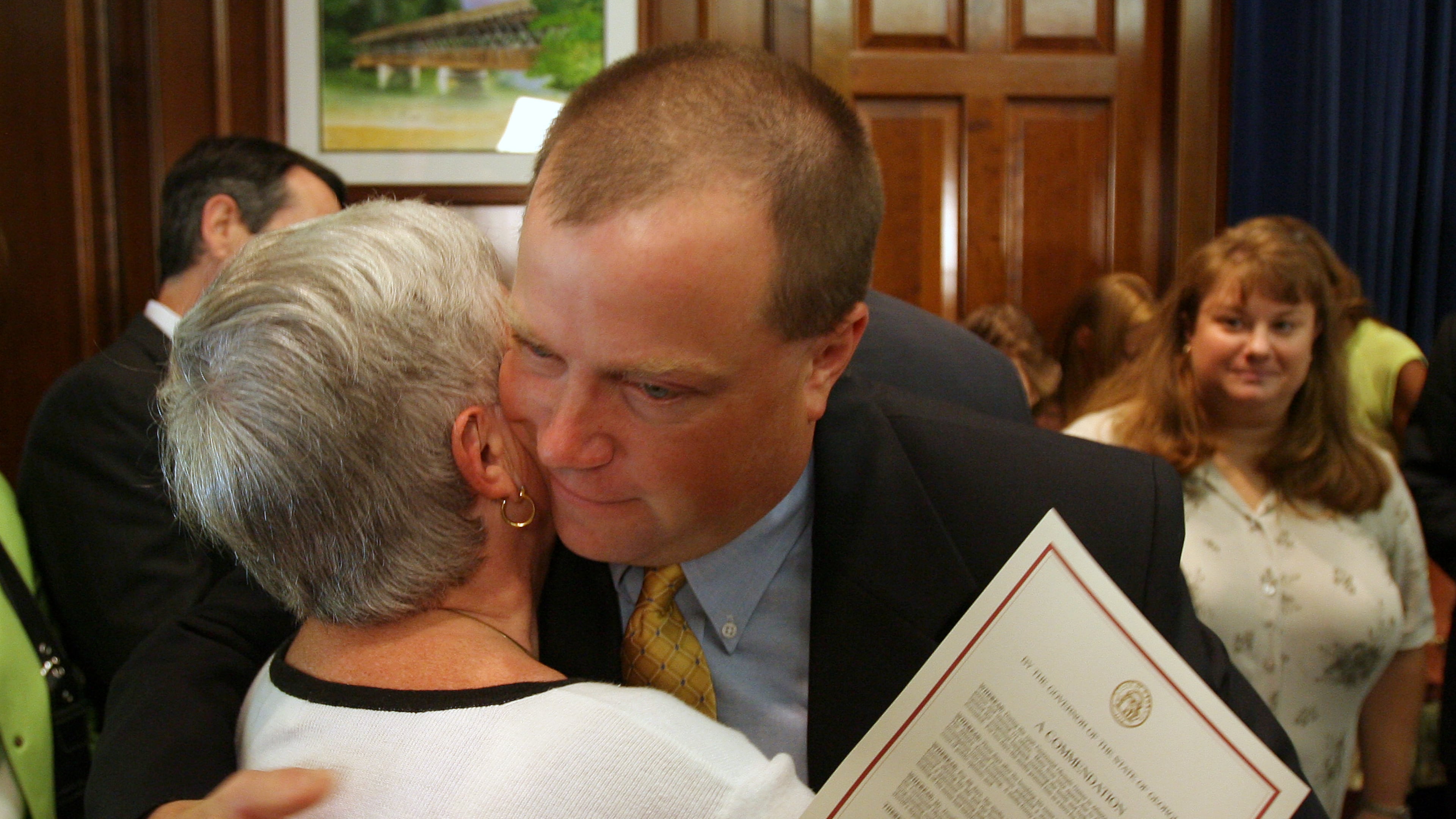 ATLANTA, GA -- Former Olympic security guard Richard Jewell hugs his mother Barbara as his wife Dana , at right, looks on Tuesday afternoon, August 1, 2006 after he received a commendation from Gov. Sonny Perdue for his service during the Olympics. (BEN GRAY/AJC staff)
