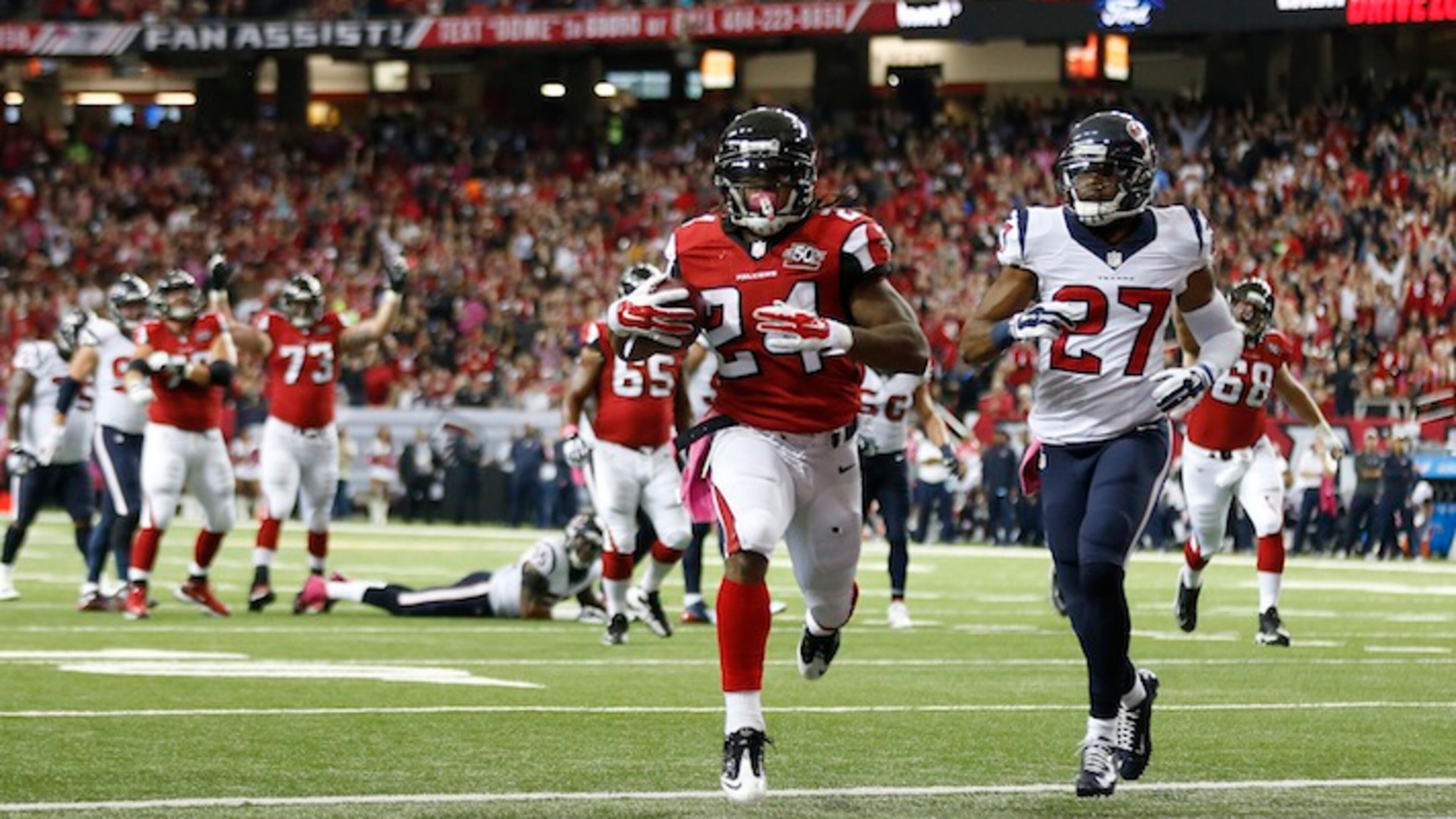 Atlanta Falcons running back Devonta Freeman (24) runs into the end zone against Houston Texans strong safety Quintin Demps (27) for a touchdown during the first half of an NFL football game, Sunday, Oct. 4, 2015, in Atlanta. (AP Photo/John Bazemore)