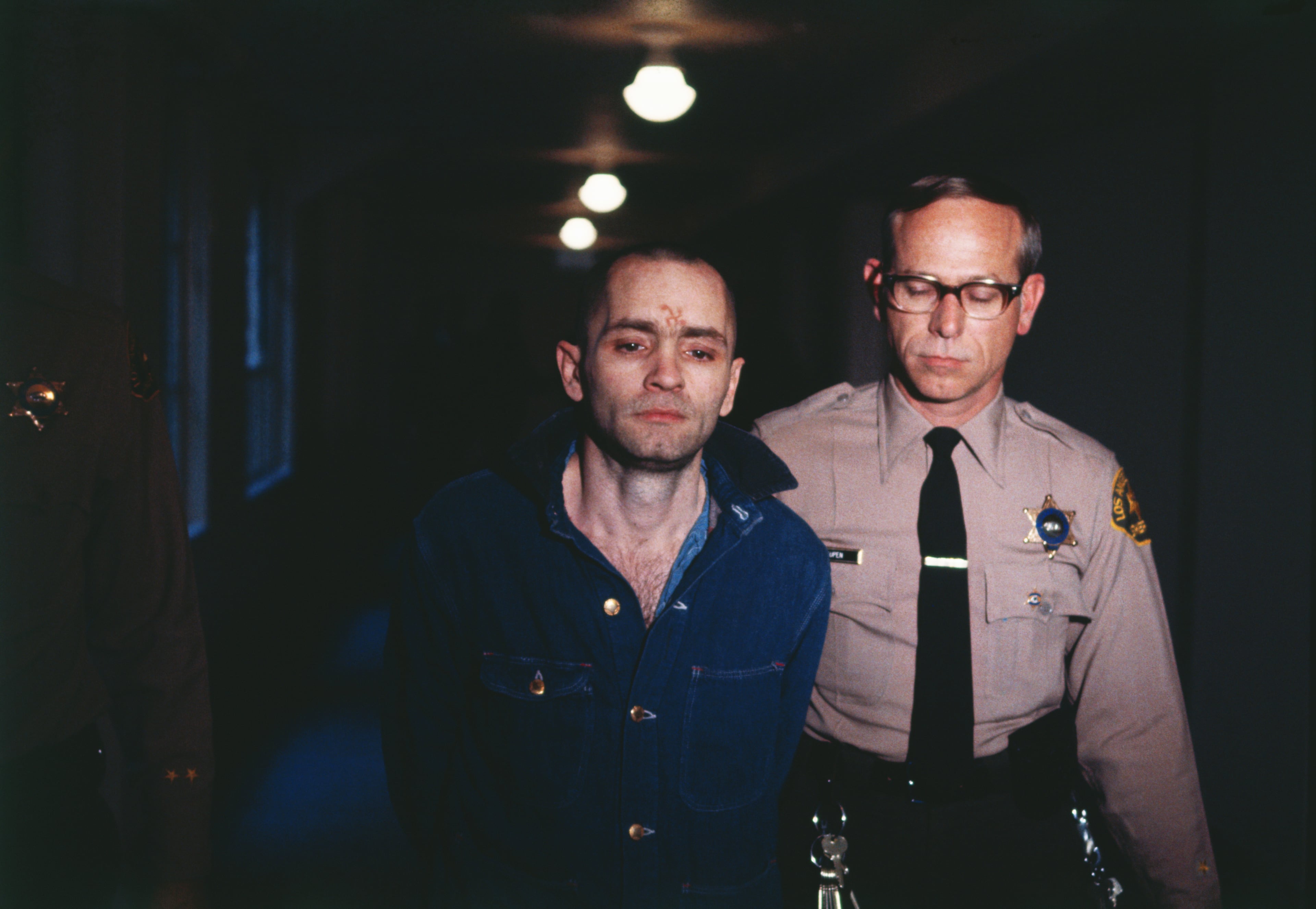 Charles Manson, convicted cult leader, is sullen as he is led back into the courtroom to hear the penalty he and this three female followers must pay for the Tate-LaBianca murders of August 1969. Manson and his followers, Denise Atkins, Patricia Krenwinkel, and Leslie Van Houten were decreed the gas chamber by the jury following a nine month trial.