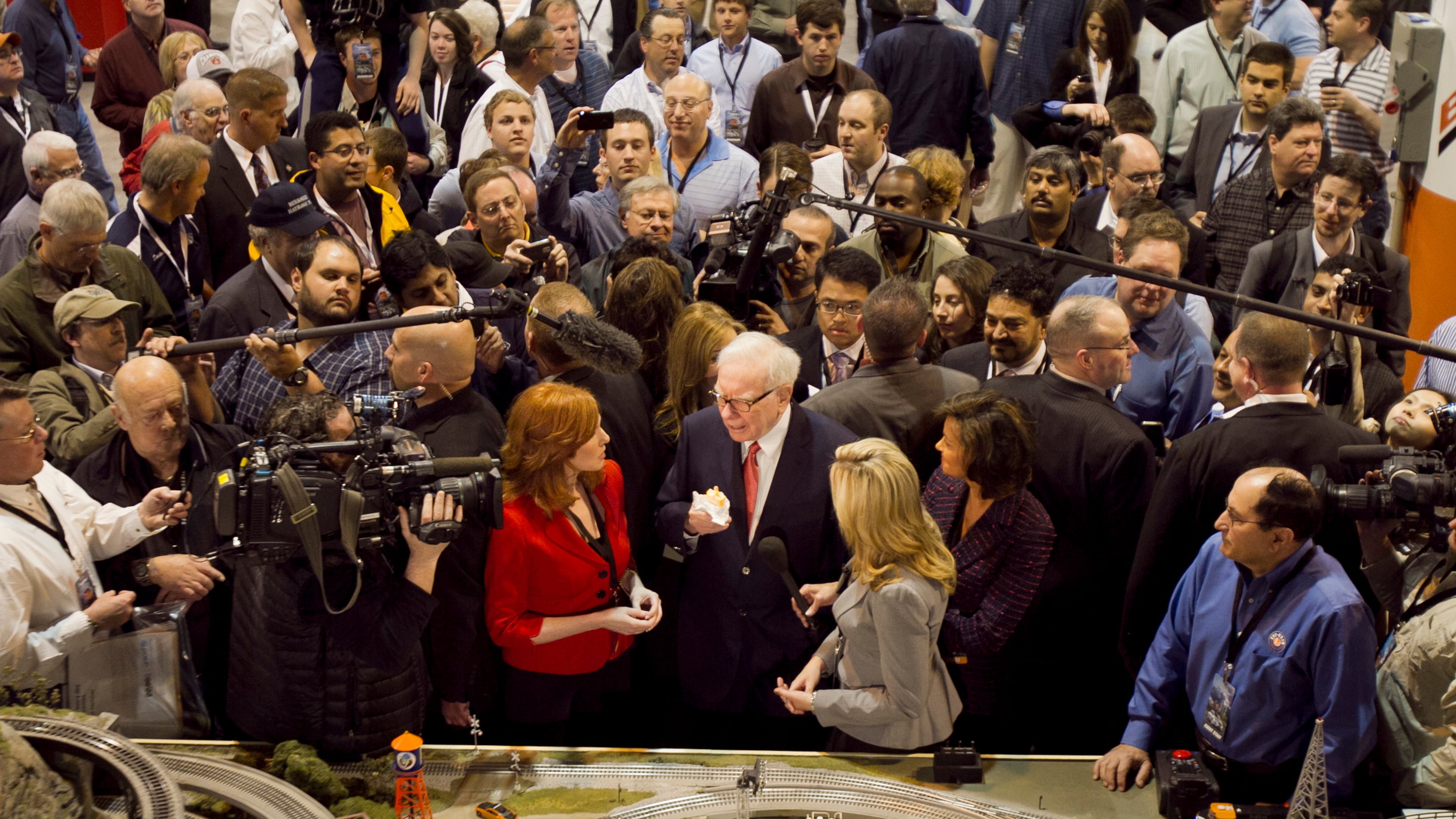 FILE - Berkshire Hathaway Chairman and CEO Warren Buffett, center, is surrounded by journalists and shareholders as he stops by a model railroad while touring the exhibit floor where Berkshire subsidiaries display their products in Omaha, Neb., April 30, 2011, prior to presiding over the annual Berkshire Hathaway shareholders meeting. (AP Photo/Nati Harnik, File)