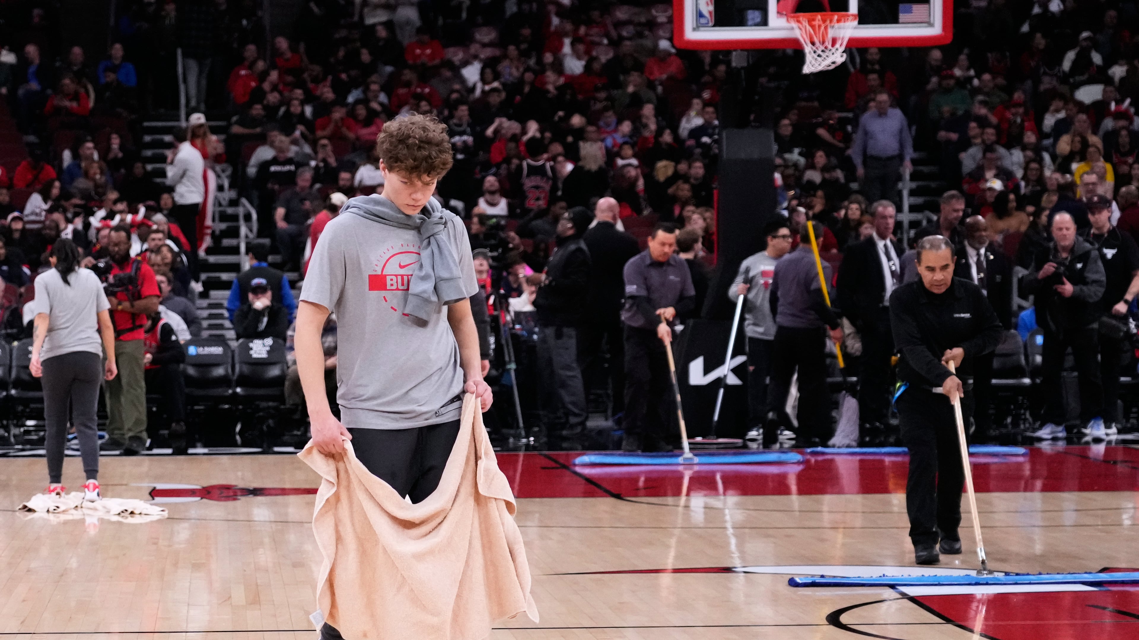 United Center employees try to dry the court before an NBA basketball game between the Miami Heat and the Chicago Bulls in Chicago, Thursday, Jan. 8, 2026. (AP Photo/Nam Y. Huh)
