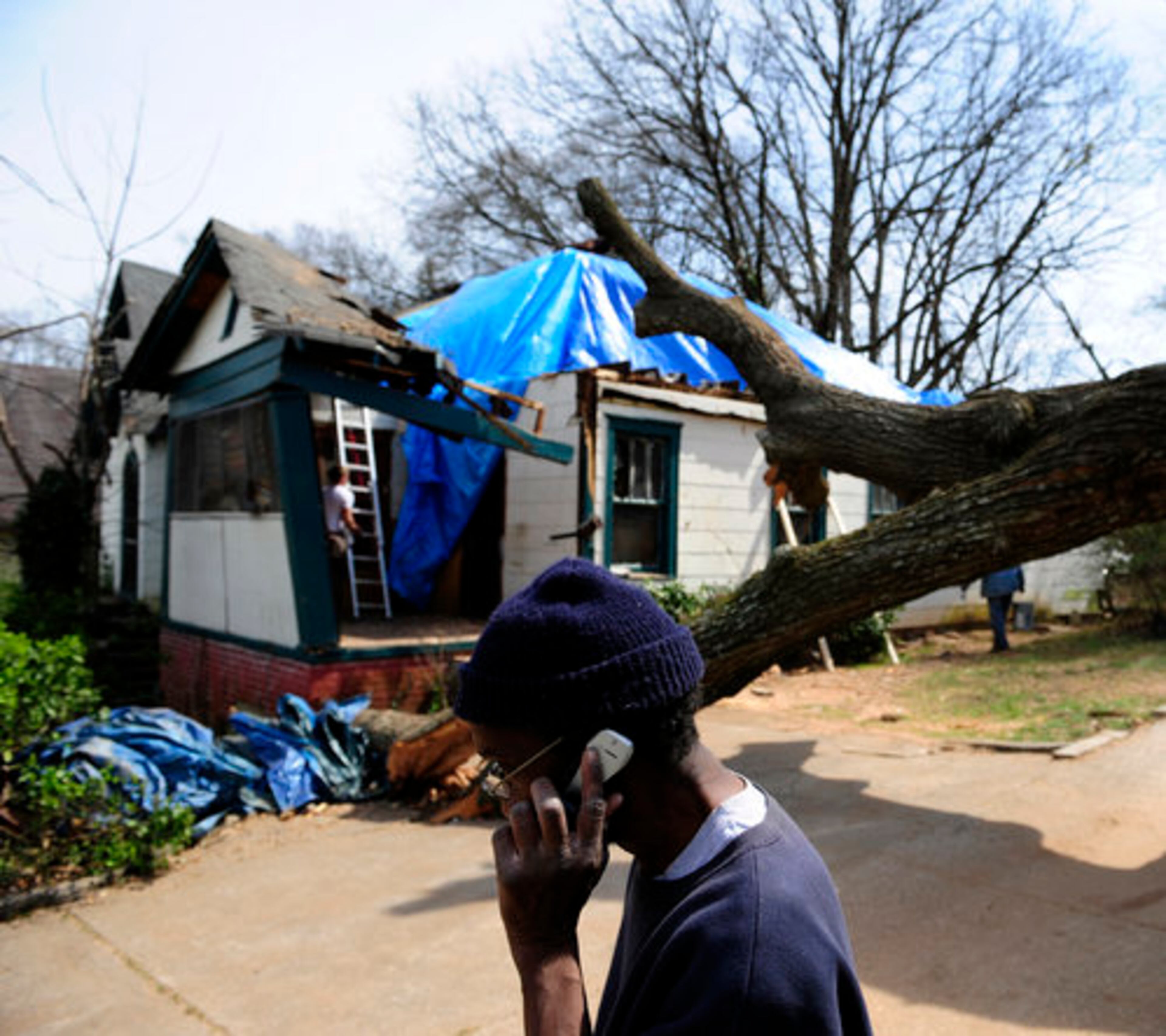 Monday: Larry McCuller, 60, from Decatur oversees work on his brother's East Atlanta home that was damaged. Volunteers from across Atlanta helped with the cleanup on Glenwood Avenue.
