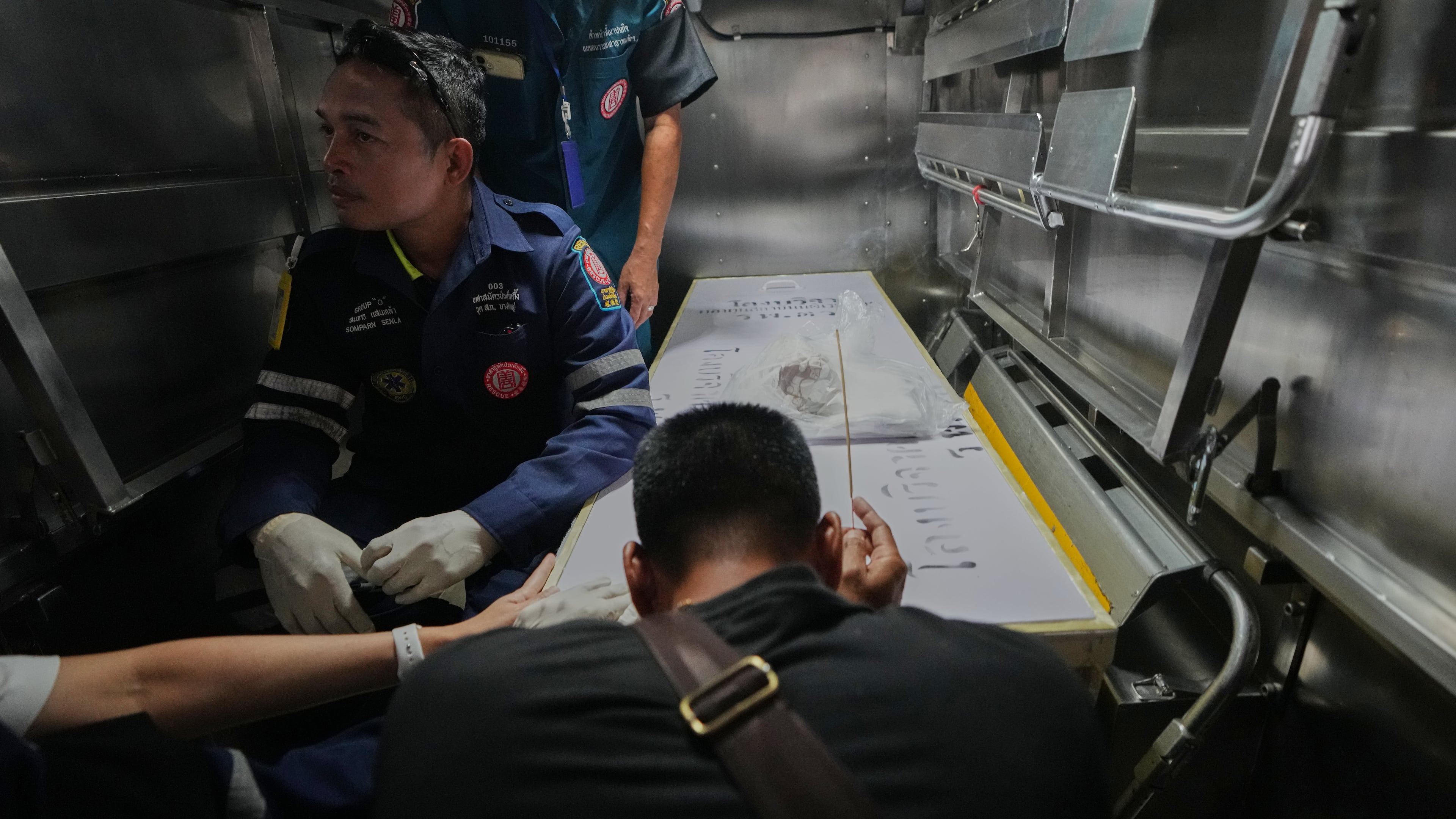 A relative of a victim in a music bar fire pays respect to the victim's body at a police hospital in Bangkok, Thailand, Tuesday, July 14, 2026. (AP Photo/Sakchai Lalit)