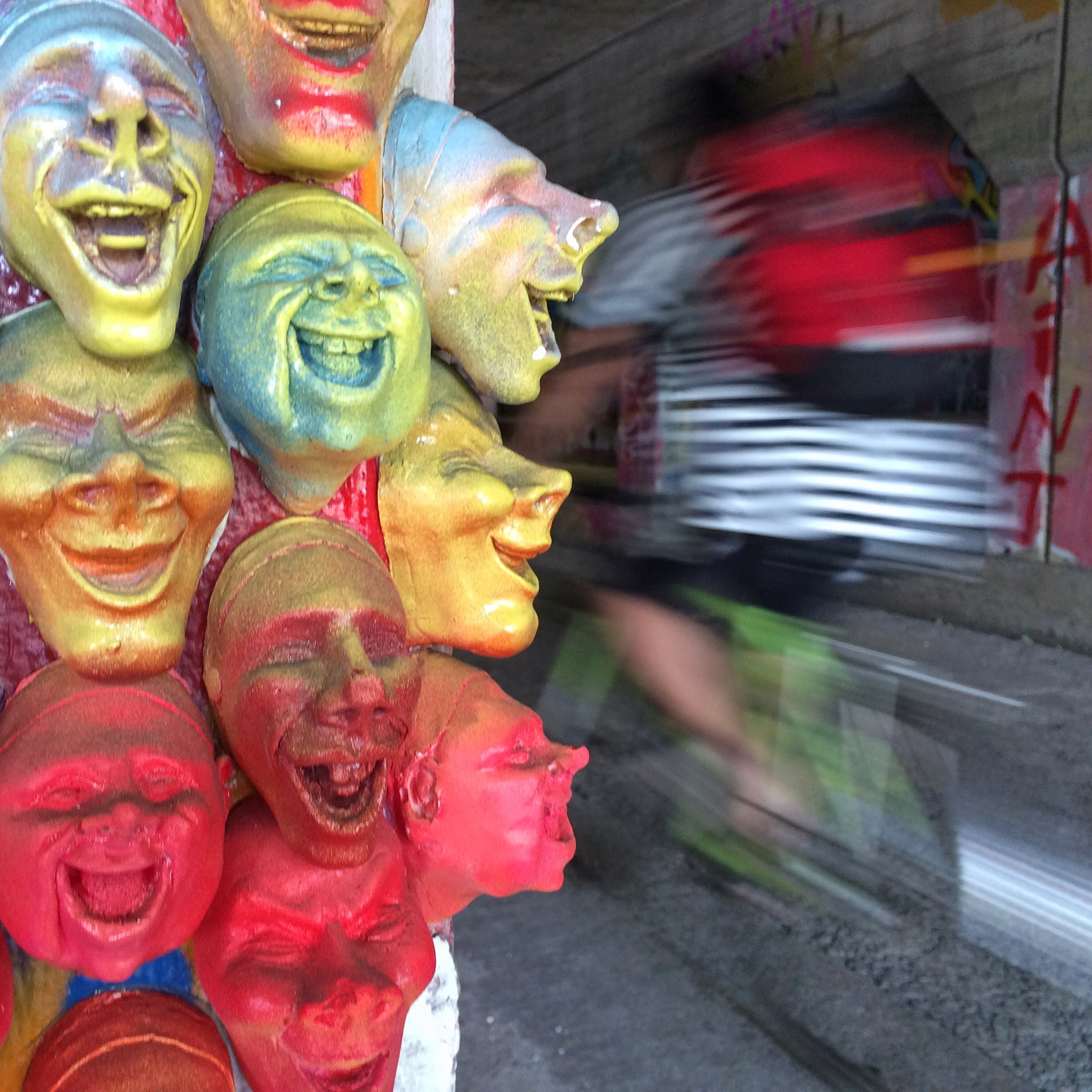 Small faces seem to laugh at a bicyclist passing through the Krog Street Tunnel. Ben Gray / @photobgray