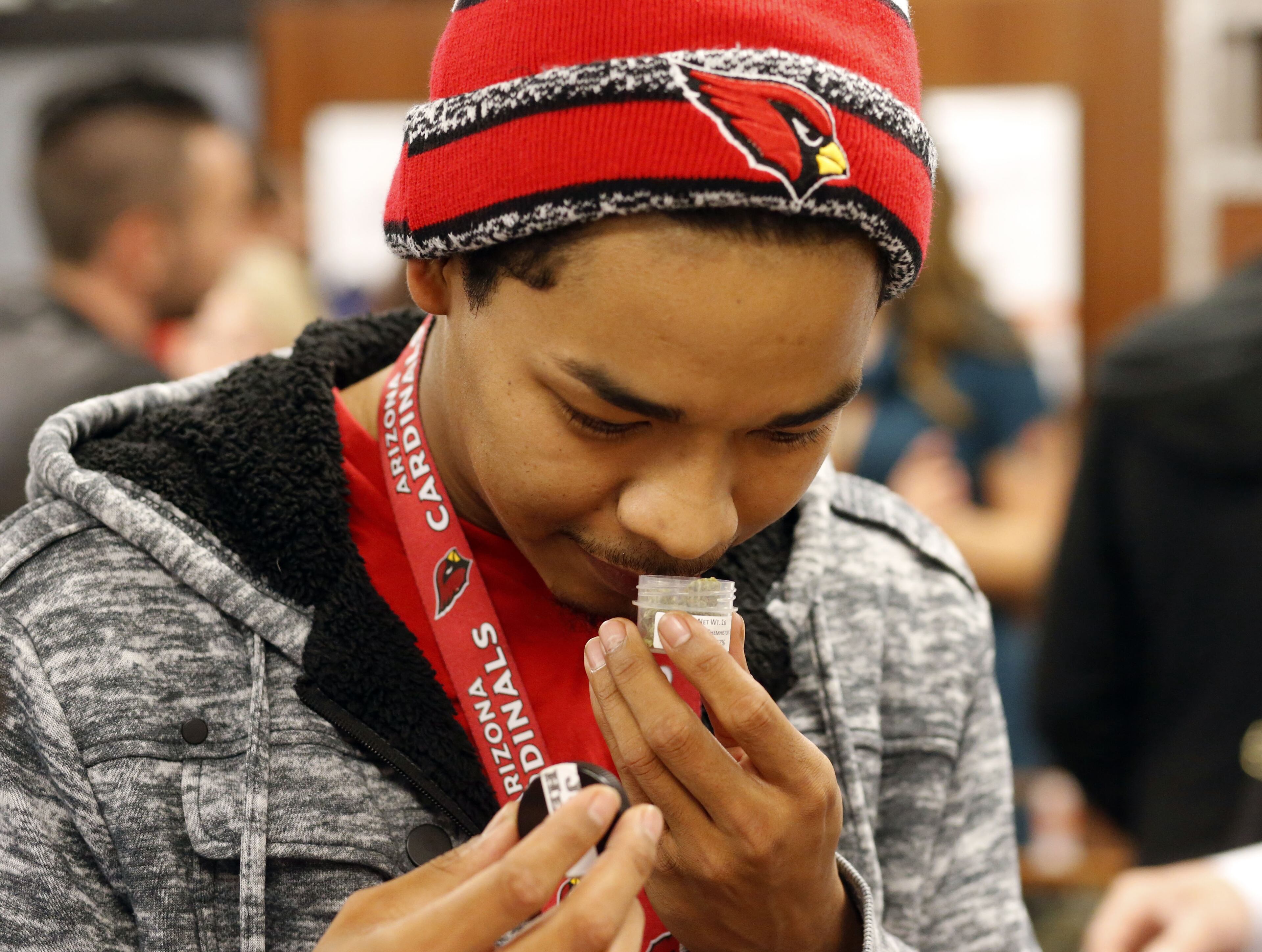 Juliano Hamana, 24, samples the aroma of one of the offerings at Shango Premium Cannabis, in Portland , Ore., Thrusday, Oct. 1, 2015. Oregon marijuana stores have begun sales to recreational users, marking a big day for the budding pot industry in the state. Some of the more than 250 dispensaries in Oregon that already offer medical marijuana opened their doors early Thursday to begin selling the drug just moments after it became legal to do so. (AP Photo/Timothy J. Gonzalez)