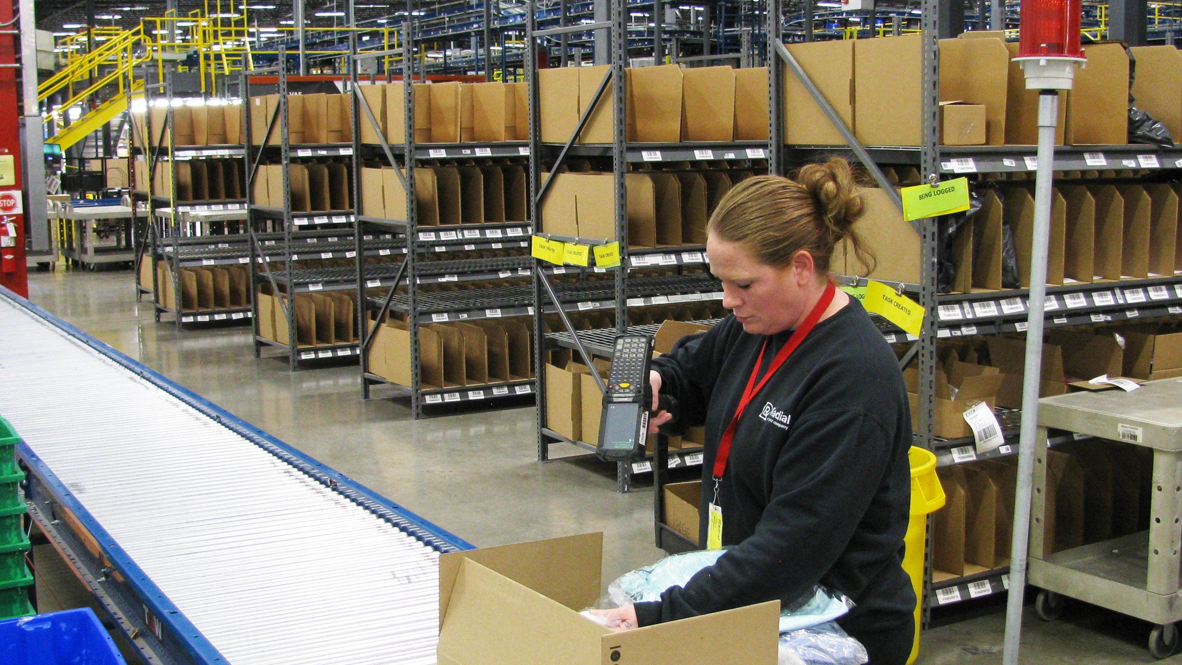 Worker packing goods to be shipped from Radial's Locust Grove distribution center. The facility is part of Radial's network of centers. The Belgian-owned company is ramping up for the seasonal rush.