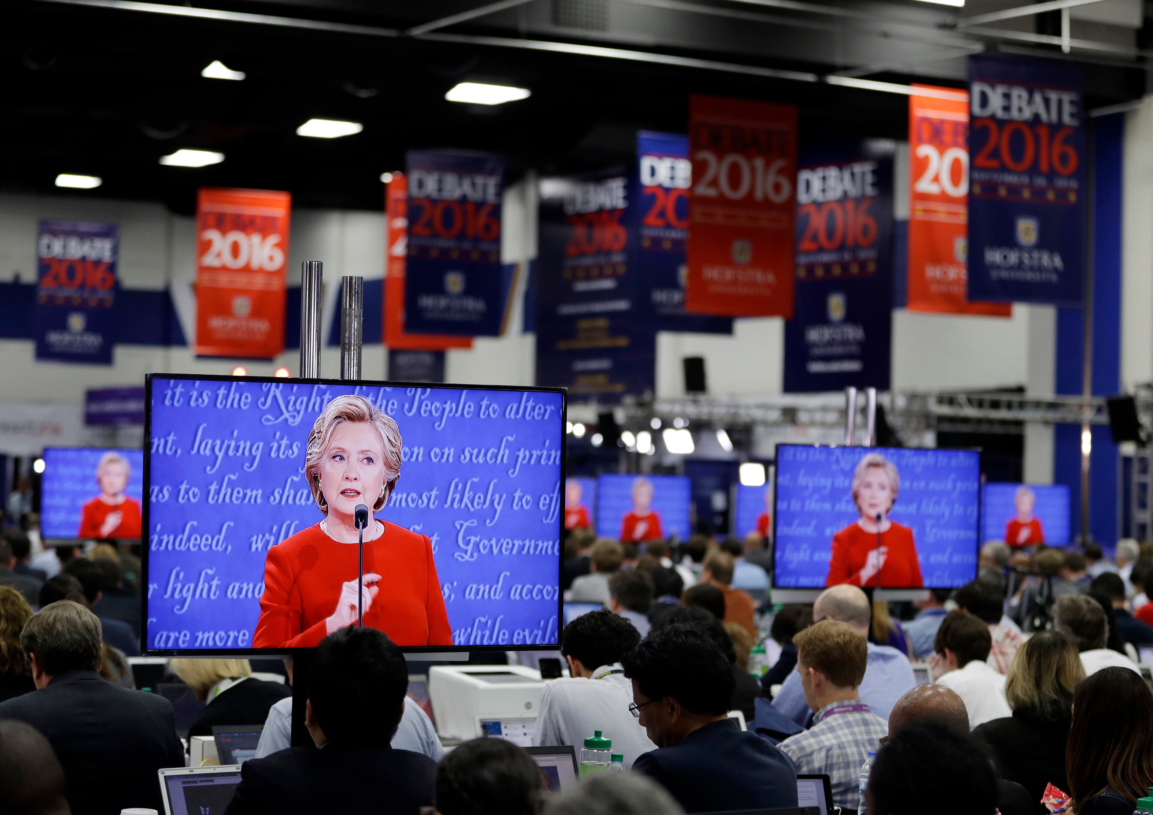 Democratic presidential candidate Hillary Clinton is seen on screens in the media center during the presidential debate between Clinton and Republican presidential candidate Donald Trump at Hofstra University, Monday, Sept. 26, 2016, in Hempstead, N.Y. (AP Photo/John Locher)