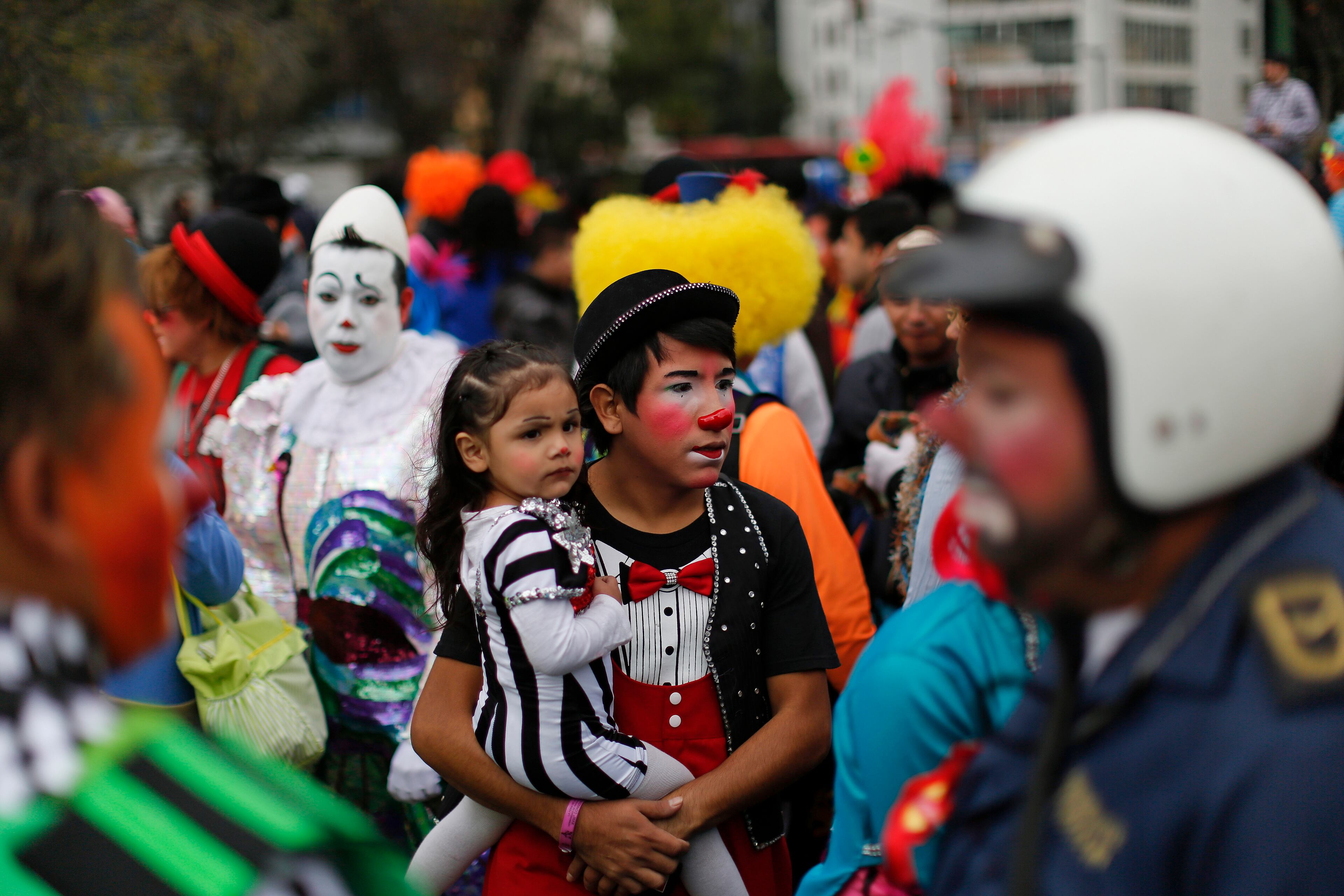 A clown carrying his daughter waits for the start of a laugh-a-thon at the 17th International Clown Convention in Mexico City, Wednesday, Oct. 23, 2013. They sought a world laugh record but no Guinness official was seen present and they fell short of 15 minutes.
