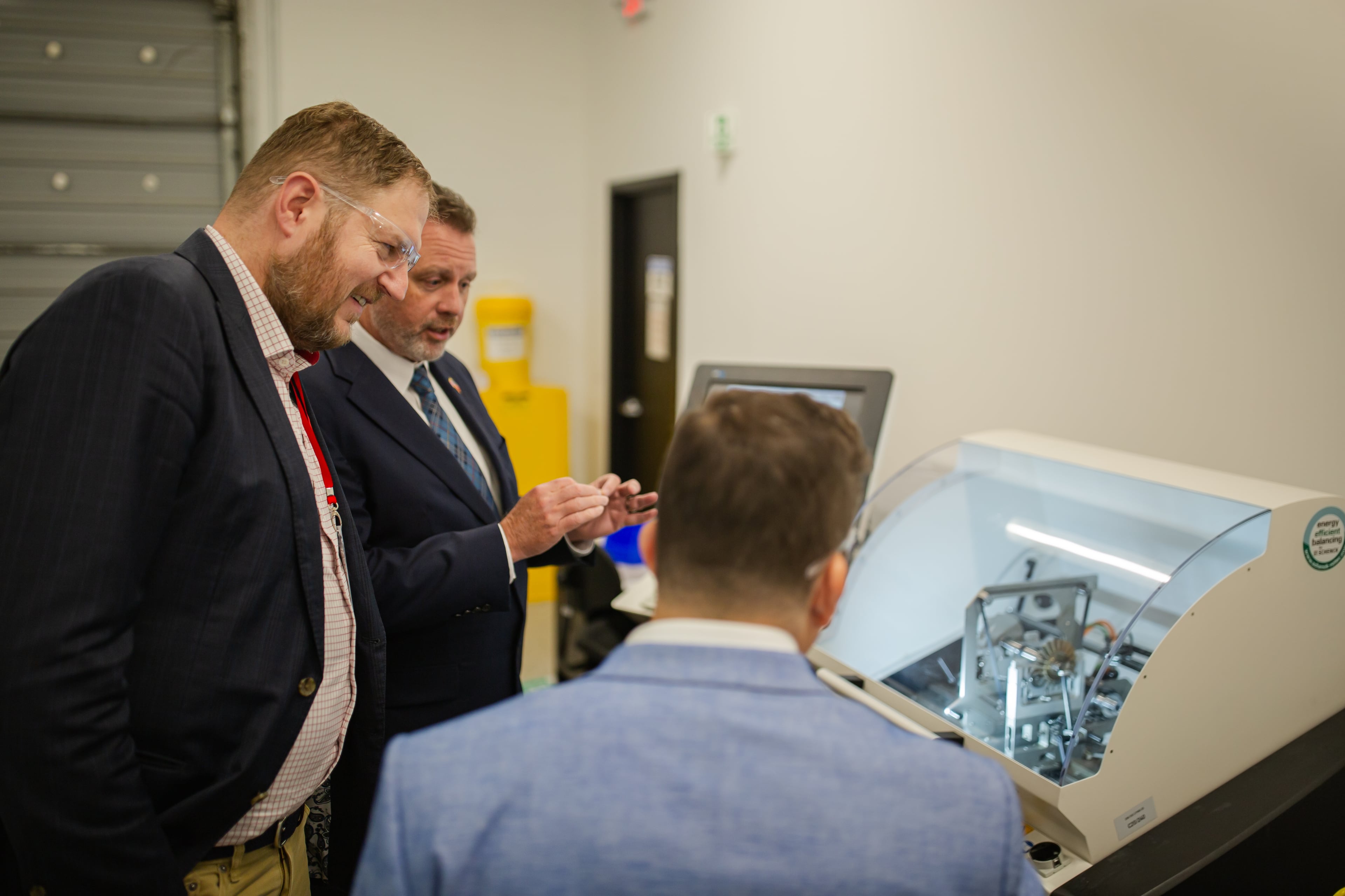 PBS Aerospace CEO Erin Durham (center) shows David Müller, deputy minister of the Czech Ministry of Industry and Trade (left)how a jet engine part is balanced. (Courtesy of Abigail Peyton Photography)