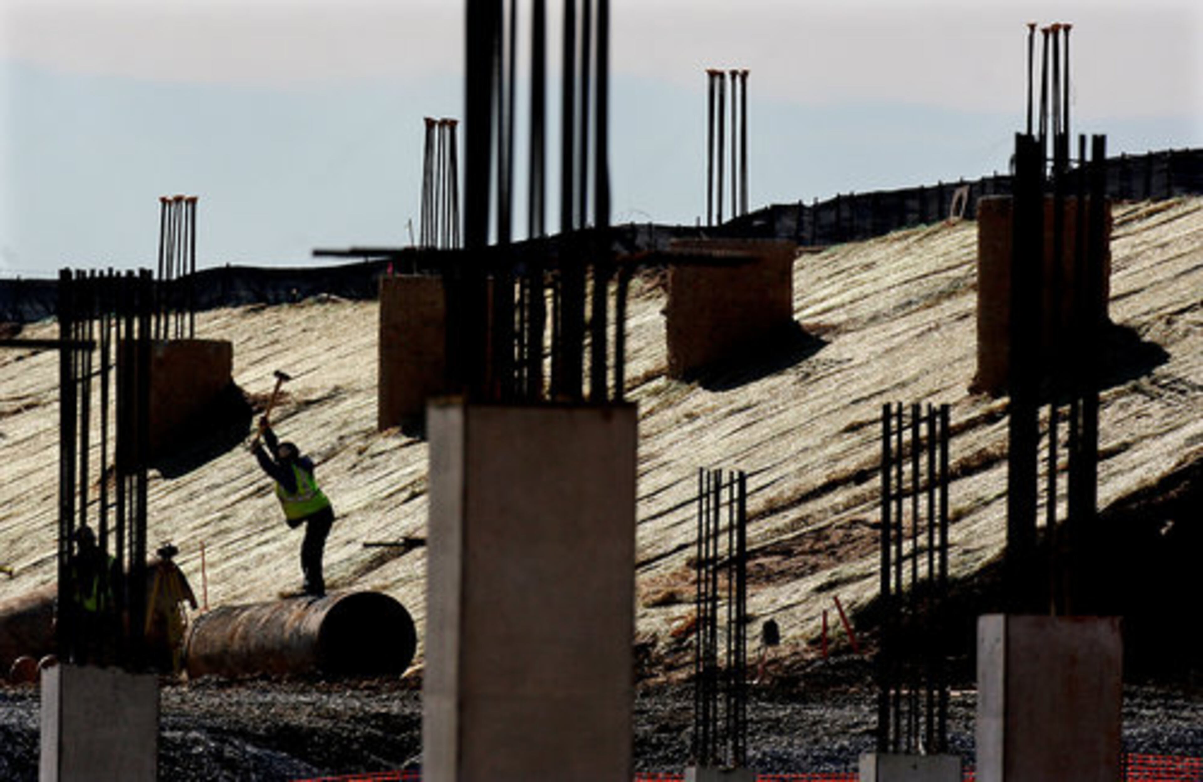 A construction worker swings a sledge hammer at Hartsfield-Jackson's long-delayed new 1.2 million square foot international terminal site.