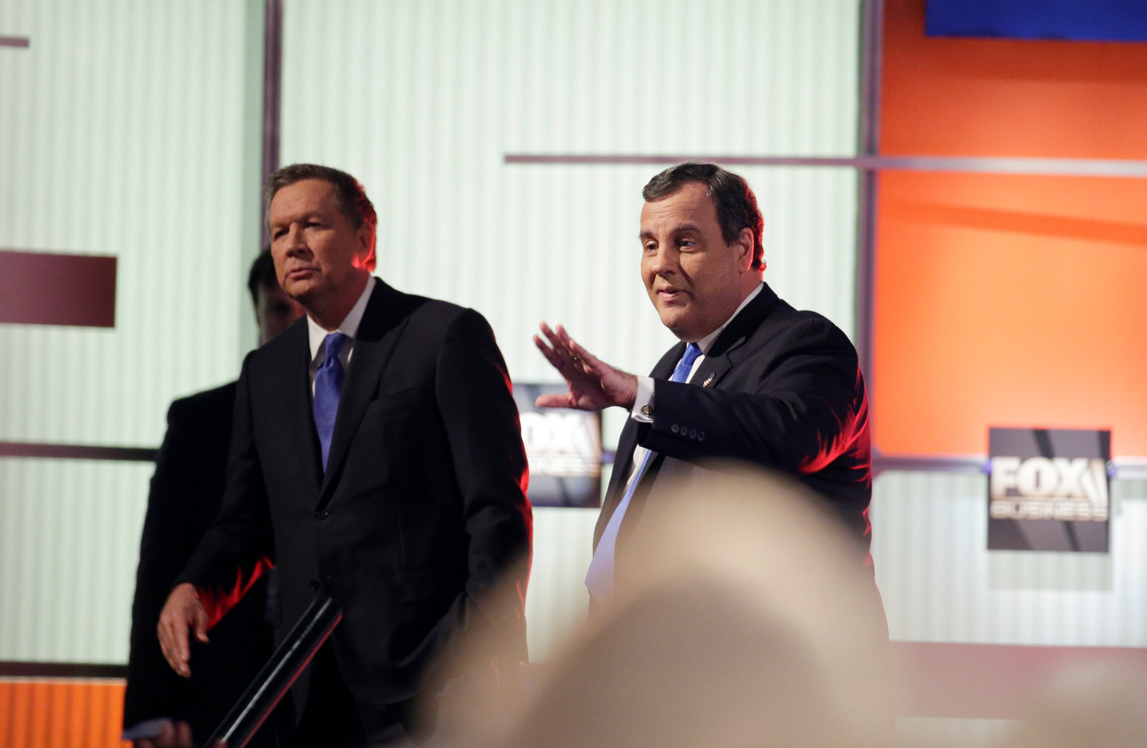 Republican presidential candidate, Ohio Gov. John Kasich, left, and Republican presidential candidate, New Jersey Gov. Chris Christie look to the crowd at a break during the Fox Business Network Republican presidential debate at the North Charleston Coliseum, Thursday, Jan. 14, 2016, in North Charleston, S.C. (AP Photo/Chuck Burton)