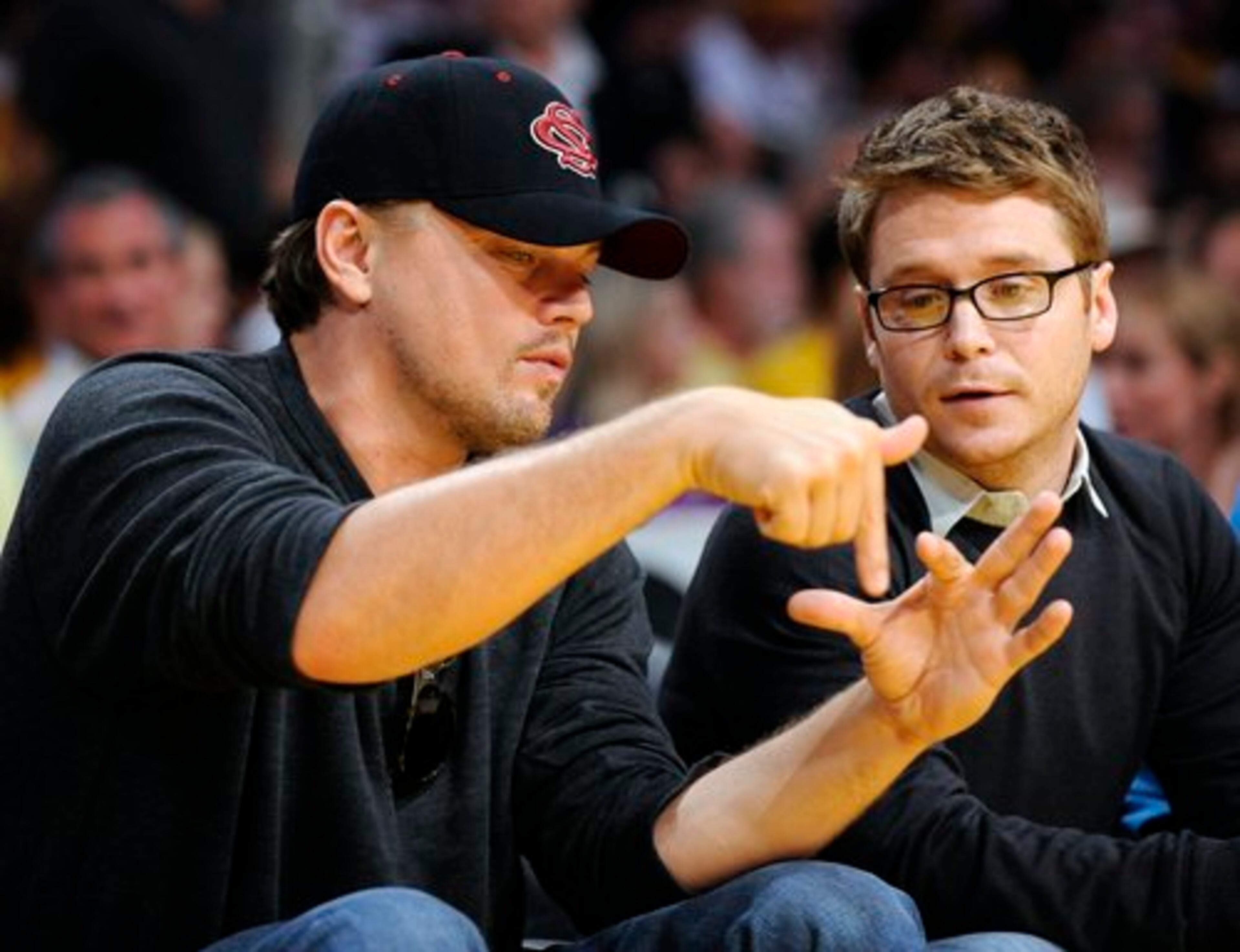 Actors Leonardo DiCaprio, left, and Kevin Connolly talk during the first half of Game 2 of the NBA basketball finals between the Los Angeles Lakers and the Boston Celtics on Sunday, June 6, 2010, in Los Angeles.