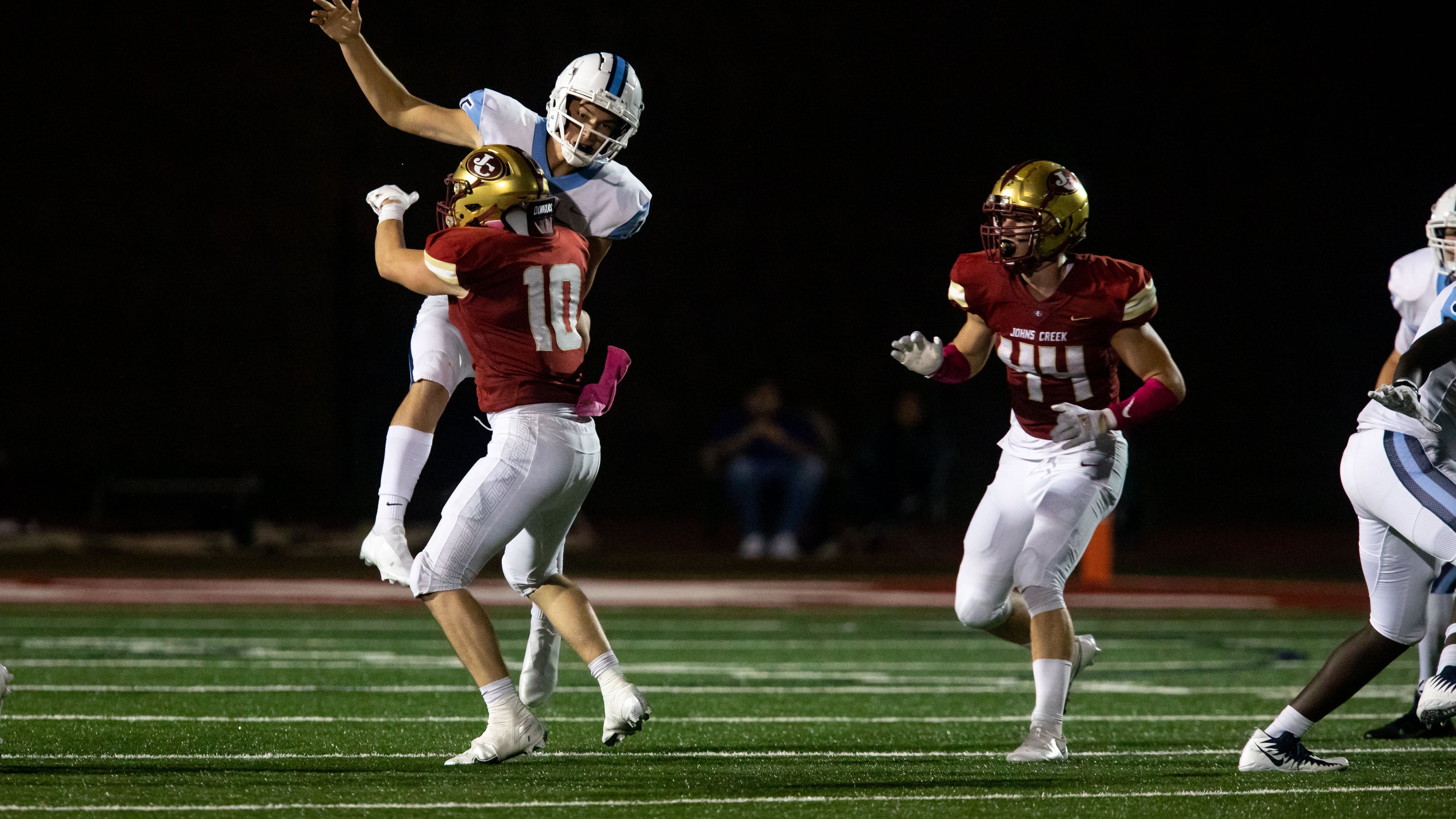 Cambridge quarterback Zach Harris (15) is tackled during a GHSA high school football game between Cambridge High School and Johns Creek High School in Johns Creek, Ga. on Friday, October 15, 2021. (Photo/Jenn Finch)