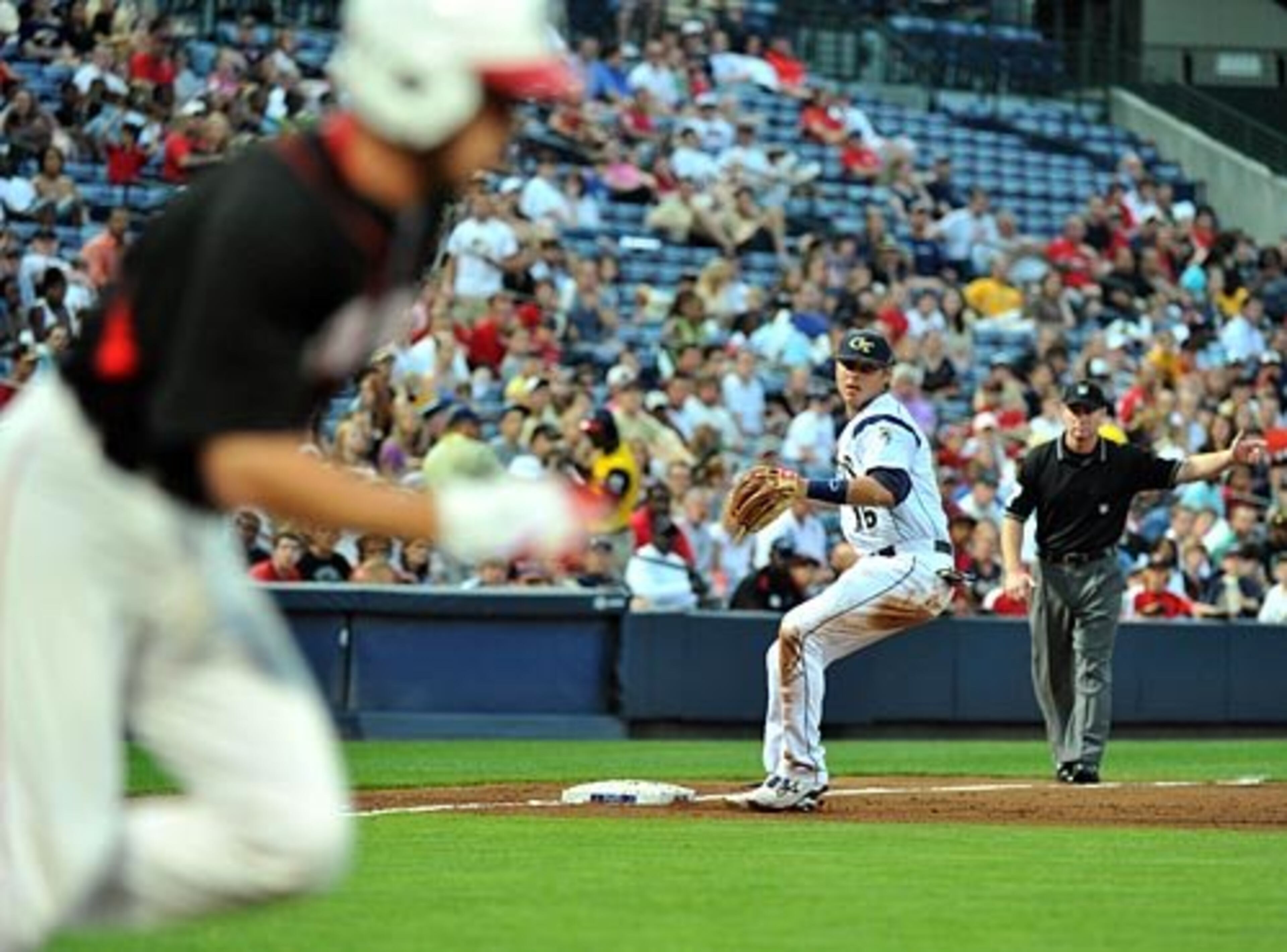 Georgia Tech's Matt Skole (16) prepares to throw to first base as UGA's Curt Powell (left) runs in the 3rd inning.