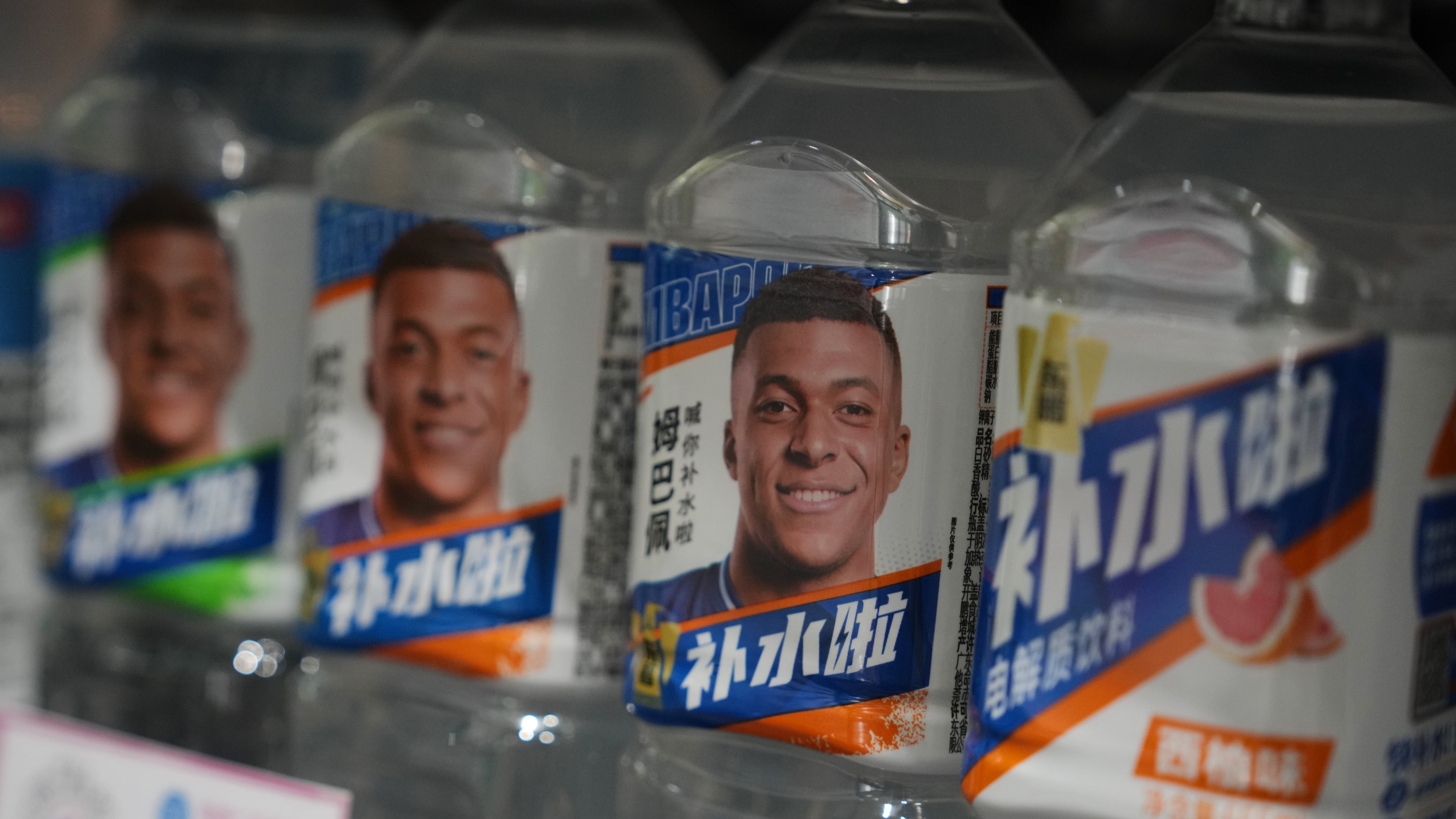 Bottles of electrolyte drink by Dongpeng Beverage Group featuring images of French soccer star Kylian Mbappé are displayed for sale at a supermarket in Beijing, Tuesday, Oct. 27, 2026. (AP Photo/Andy Wong)