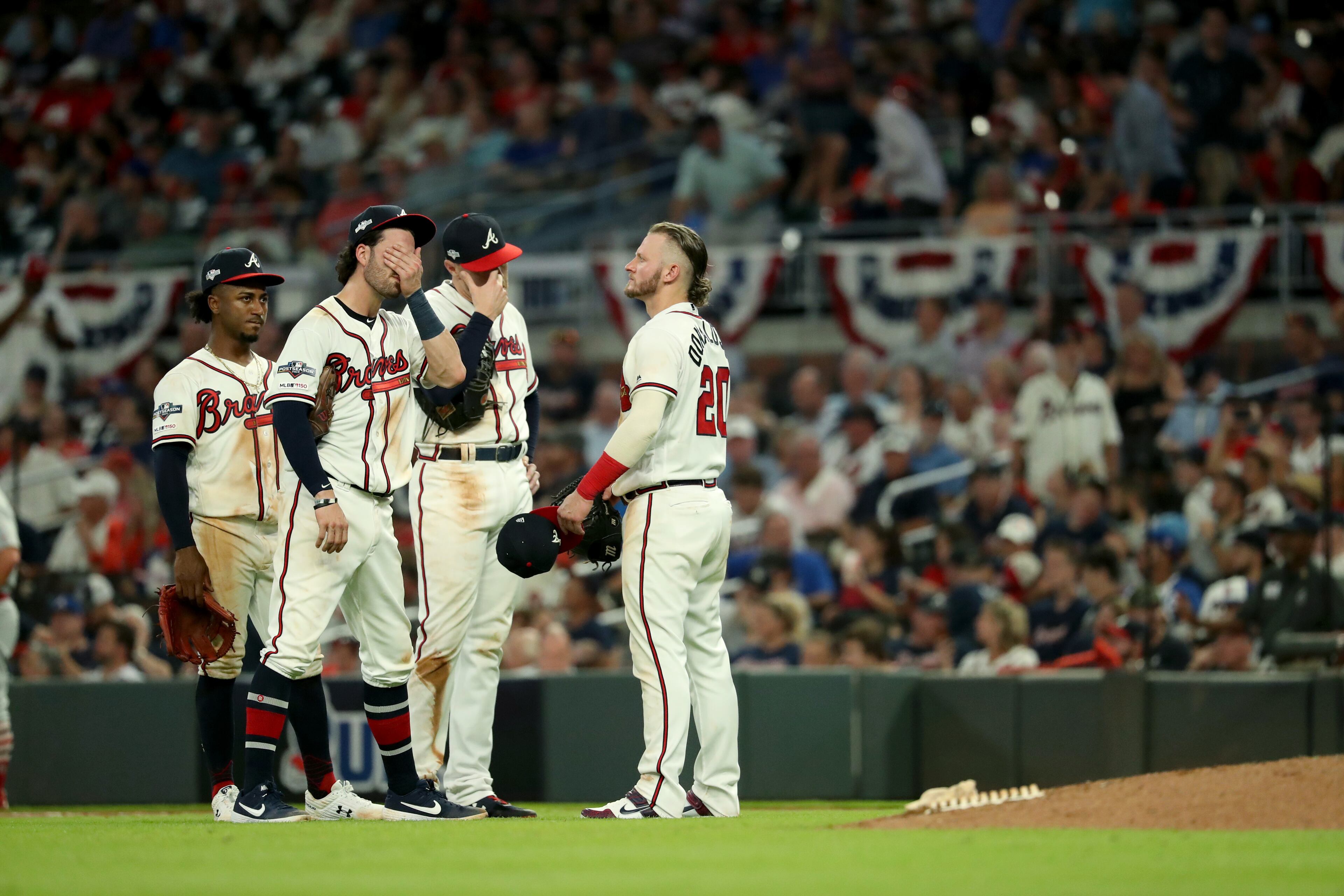 Braves second baseman Ozzie Albies (1), shortstop Dansby Swanson (7), first baseman Freddie Freeman (5), and third baseman Josh Donaldson (20) react during a pitching change after they gave up a two-run double to St. Louis Cardinals second baseman Kolten Wong in the ninth inning during Game 1 of the NLDS. The Braves lost 7-6 to the Cardinals. (JASON GETZ/SPECIAL TO THE AJC)