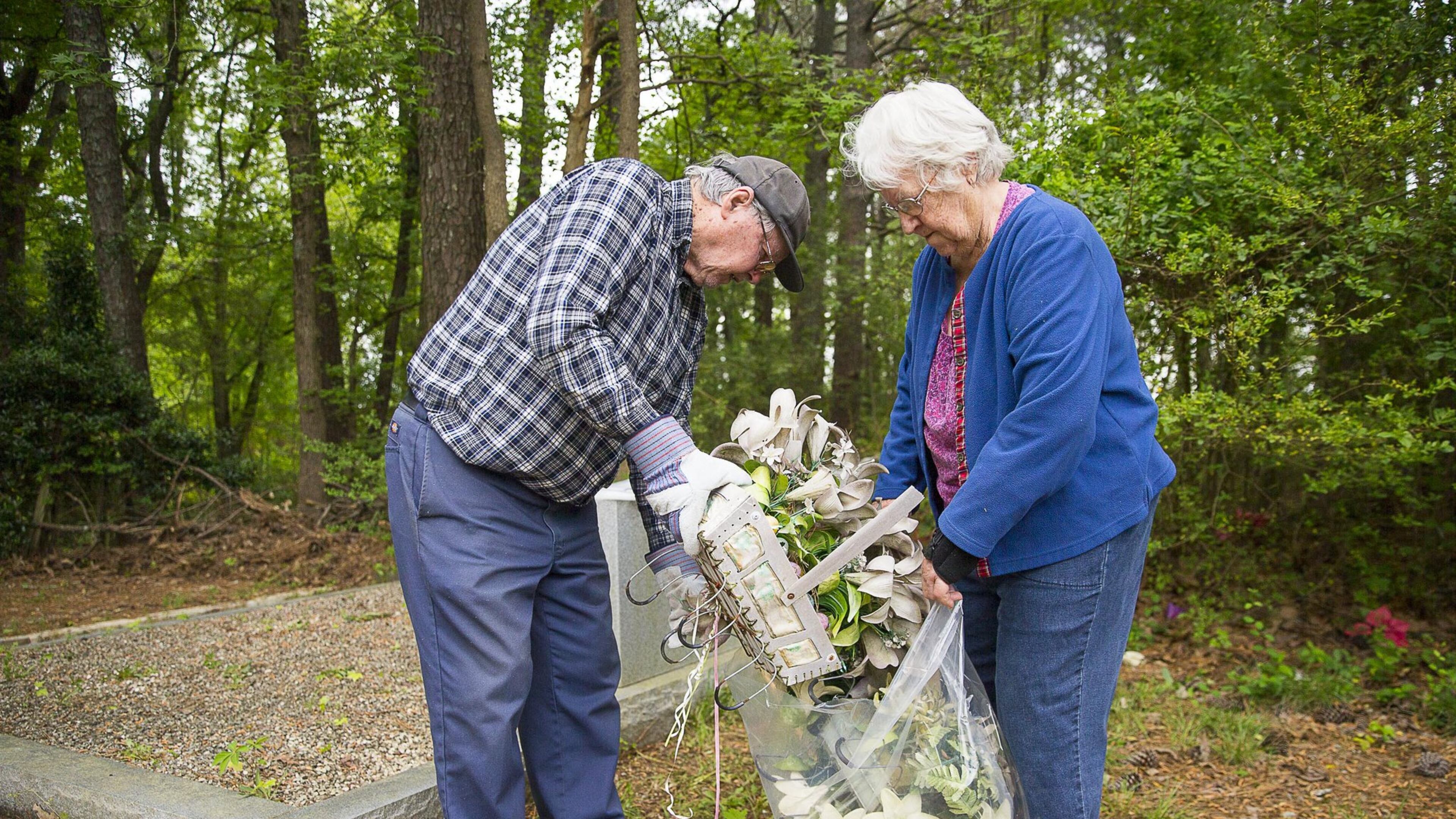 04/18/2019 — Marietta, Georgia — Marvin and Geneva Dunn of Cherokee County clean up their family’s graves at Holly Springs Cemetery, located at 2799 Holly Springs Road, Marietta. The couple heard from a relative about the suspected vandalism at the cemetery and were relieved that Marvin Dunn’s family’s tombstones had not been effected. (ALYSSA POINTER/ALYSSA.POINTER@AJC.COM)