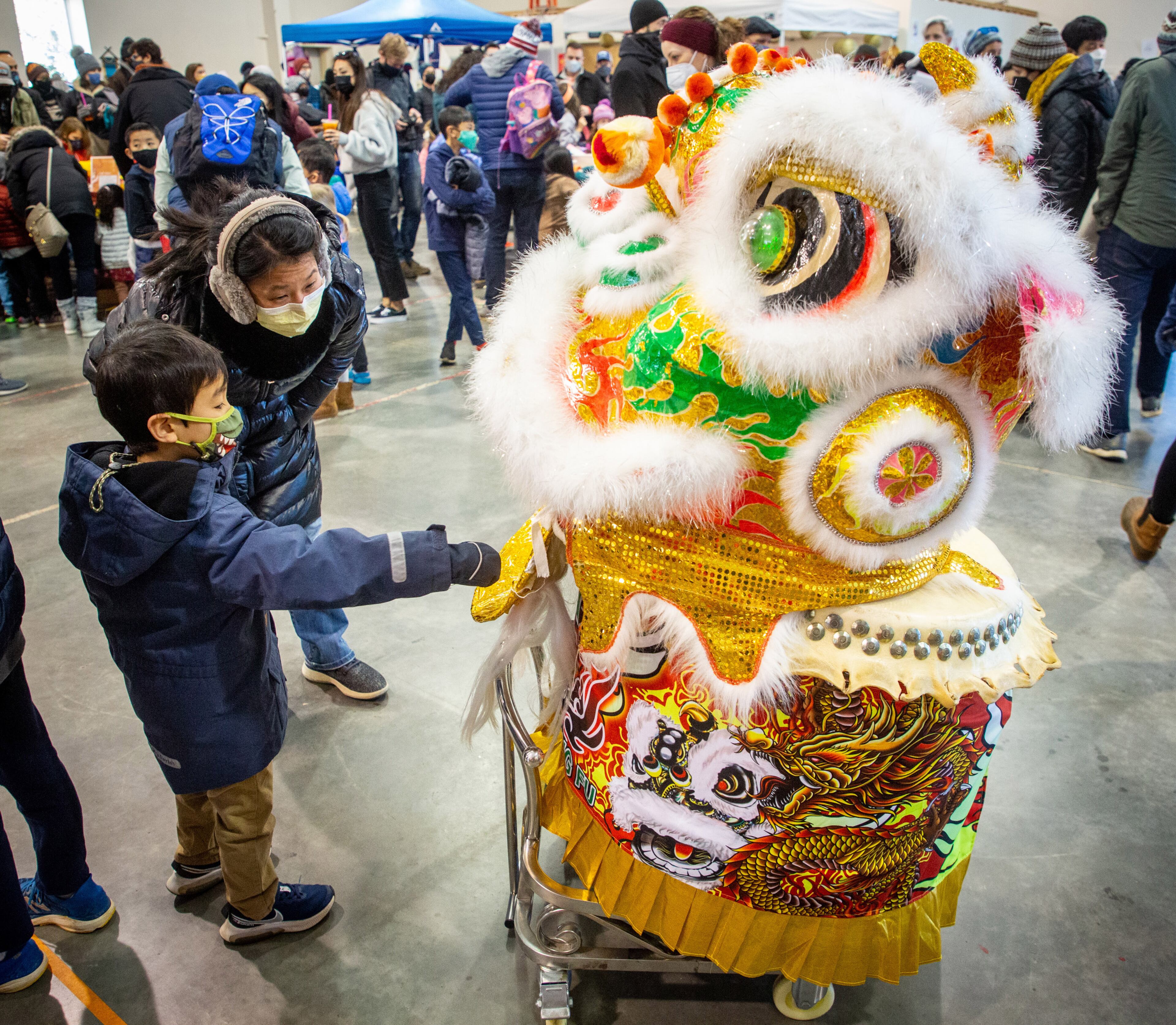 People look over one of the costumes before the start of the Lion Dance during Decatur's first Lunar New Year celebration at Legacy Park on Saturday, January 29, 2022. This will be the Year of the Tiger. STEVE SCHAEFER FOR THE ATLANTA JOURNAL-CONSTITUTION
