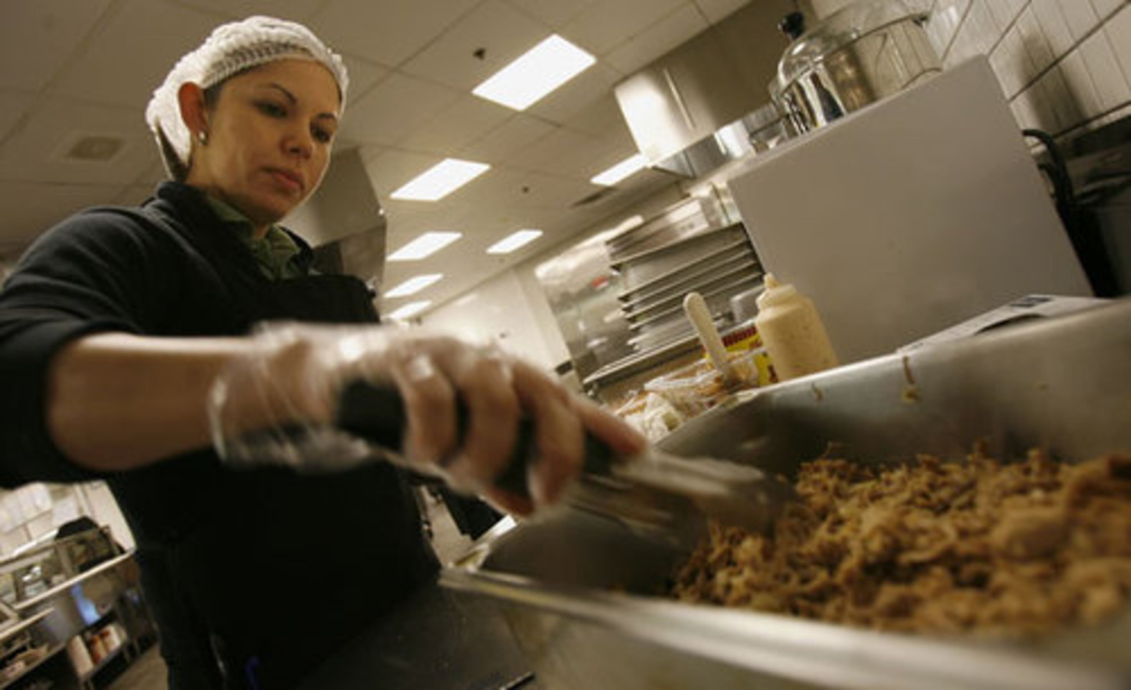 Jennifer Chevere makes carnitas in the kitchen.