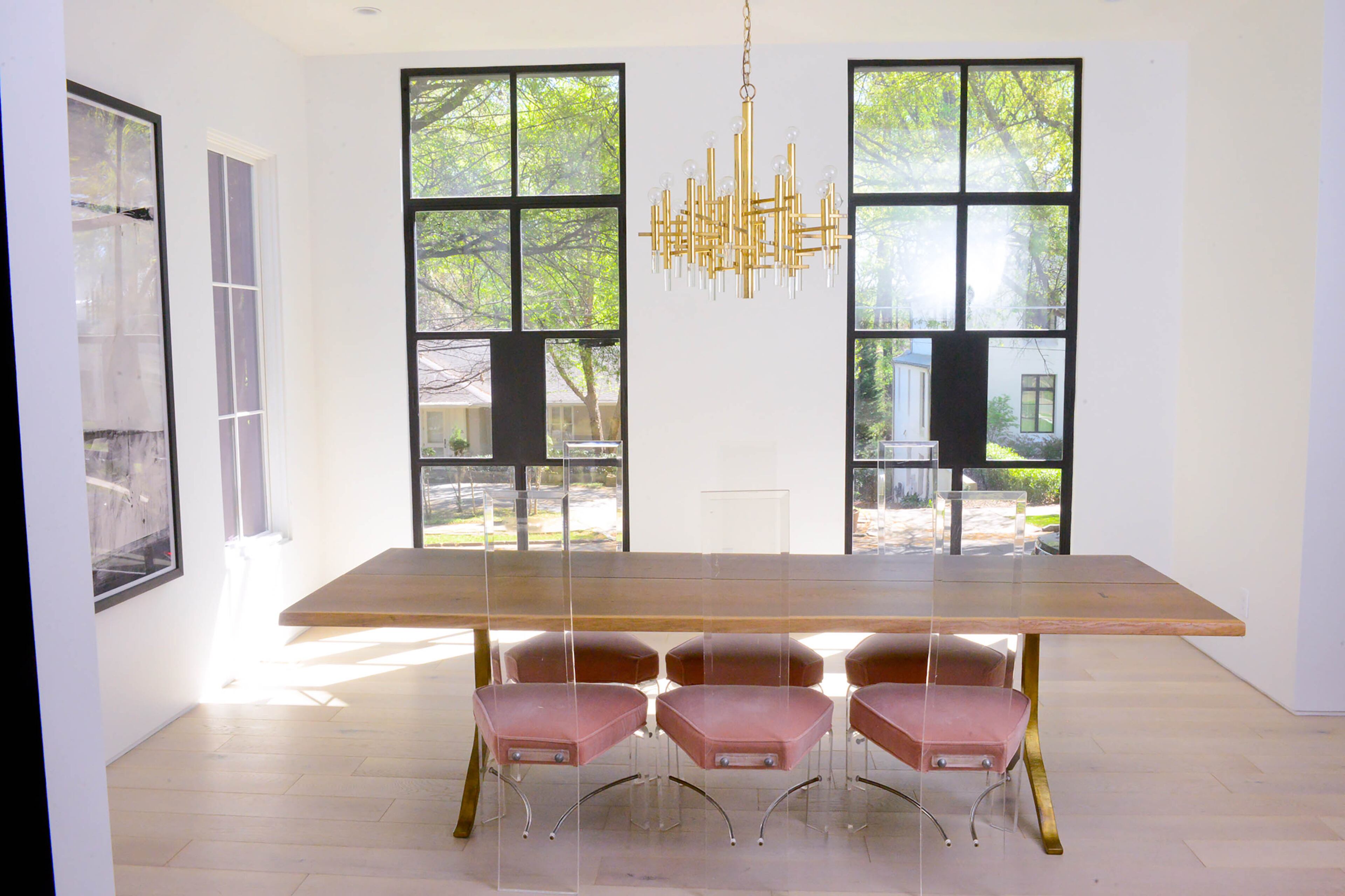 Although the Normarks based their massive renovation on the original footprint of their 1927 home, only the foundation at the front right corner of the home remains. That corner was originally the home's dining room, and the couple preserved it for that use. They added iron windows and outfitted the space with a simple dining table surrounded by chairs from Ansley Antiques.