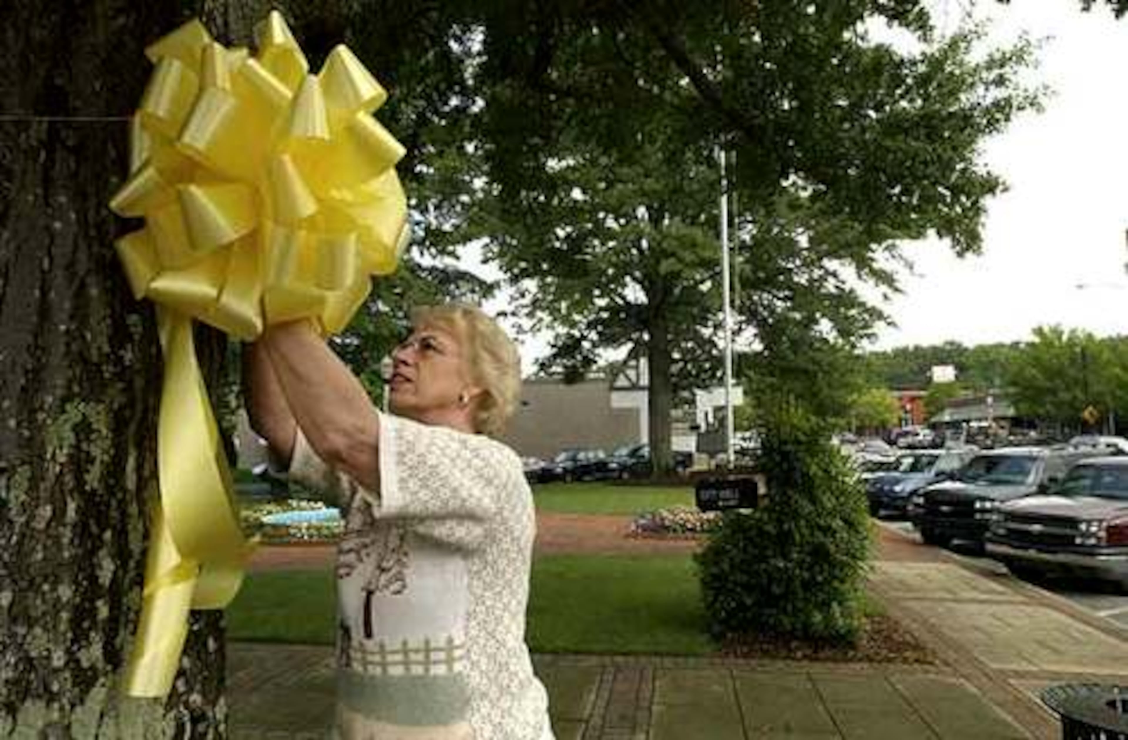 In June 2005, Doris Kenny attaches a yellow ribbon to a tree in front of City Hall in Mountain Brook, Ala., for Natalee Holloway.