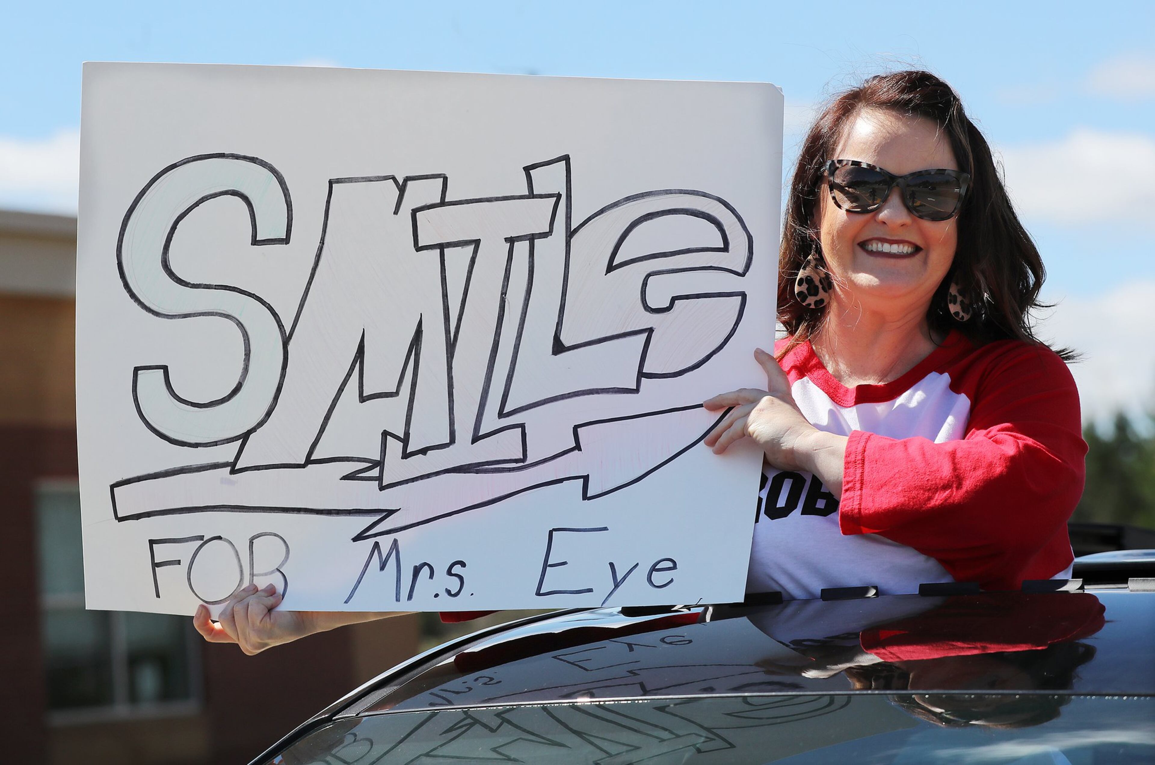 Third grade teacher Tracy Eve flashes her sign as teachers from Roberts Elementary drive through nearly two dozen area neighborhoods for some face-to-face contact while still maintaining social distance to ease the separation anxiety of their students during the coronavirus on Wednesday, March 25, 2020, in Suwanee. CURTIS COMPTON CCOMPTON@AJC.COM