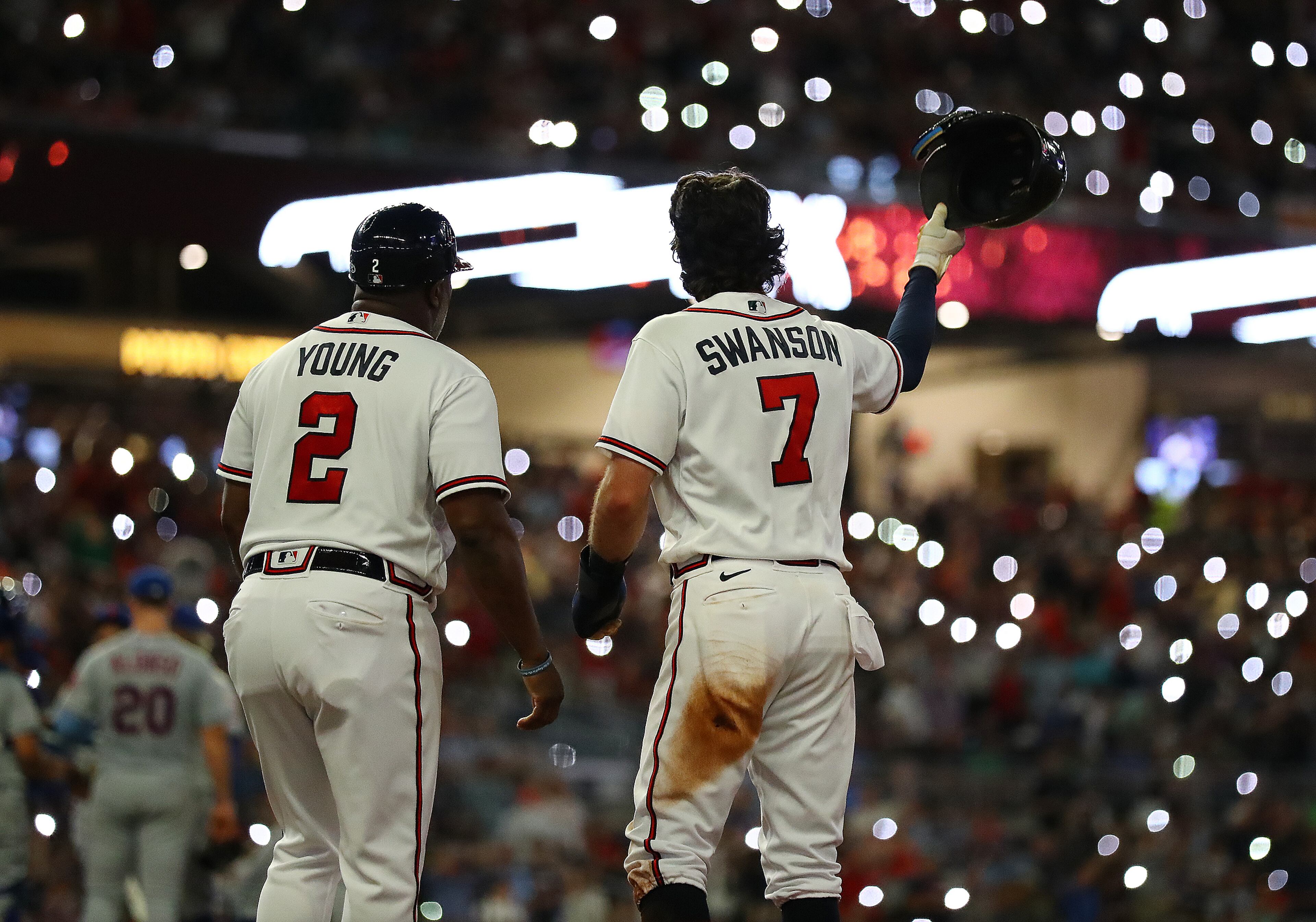 Atlanta Braves shortstop Dansby Swanson and first base coach Eric Young react to the fans with the lights turned out while the New York Mets change pitchers after his RBI-single to score outfielder Ronald Acuna for a 4-0 lead over the Mets during the seventh inning in a MLB baseball game on Tuesday, August 16, 2022, in Atlanta. The Braves shut out the Mets 5-0. “Curtis Compton / Curtis Compton@ajc.com