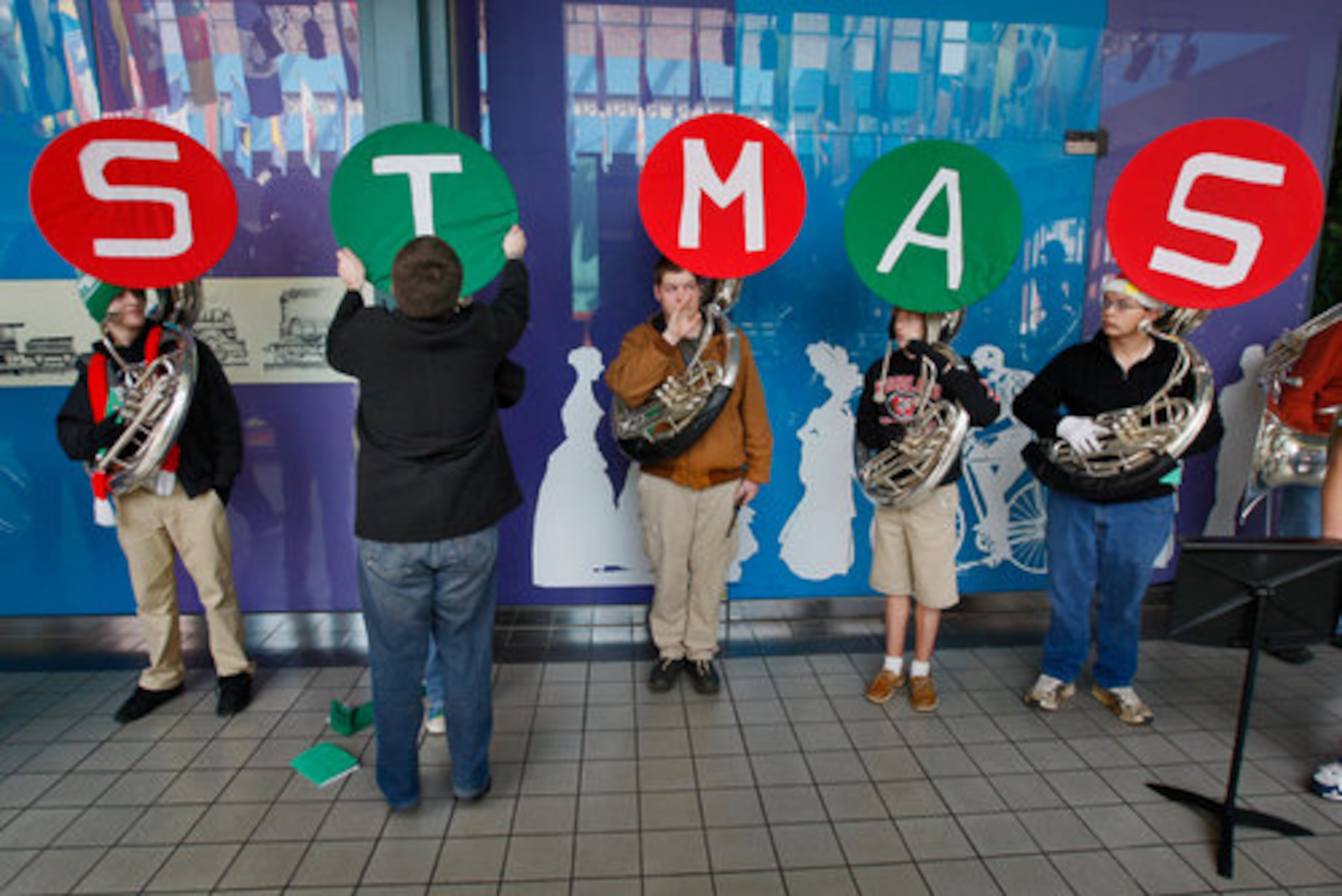 Fourteen-year participant, Andy Hertel (left center) straightens out the susaphone coverings of musicians, Left to right: Jake Brewer, 16, Jr., Jess Edwards, 16, So., Will Green, 17, Josh Shelton, 15, Fr., Woodland HS and Sean Lawson, 16, So. Some 200 musicians ranging from 11 to 71 came together Friday, Dec. 4, 2009 for TUBACHRISTMAS at Underground Atlanta.