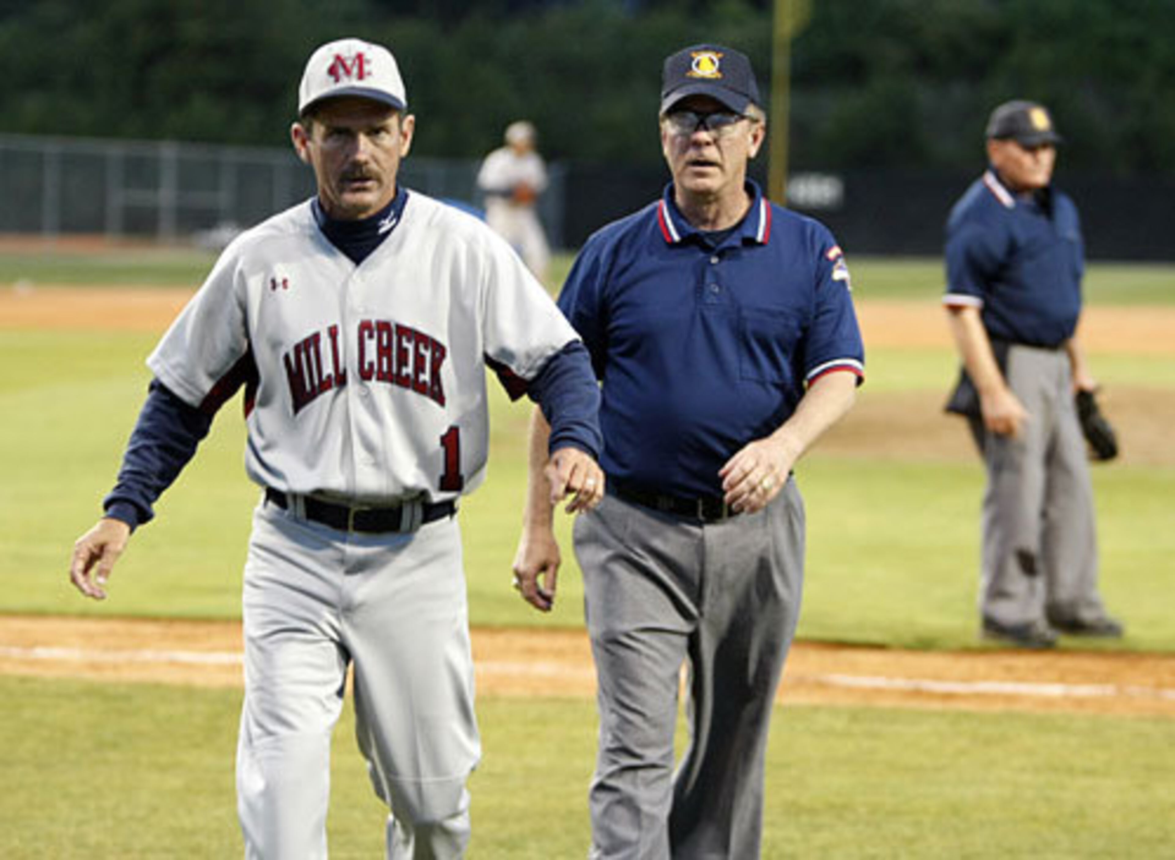 Mill Creek head coach Doug Jones is ejected from the game and escorted off the field after arguing a call during extra inning action against Hillgrove.