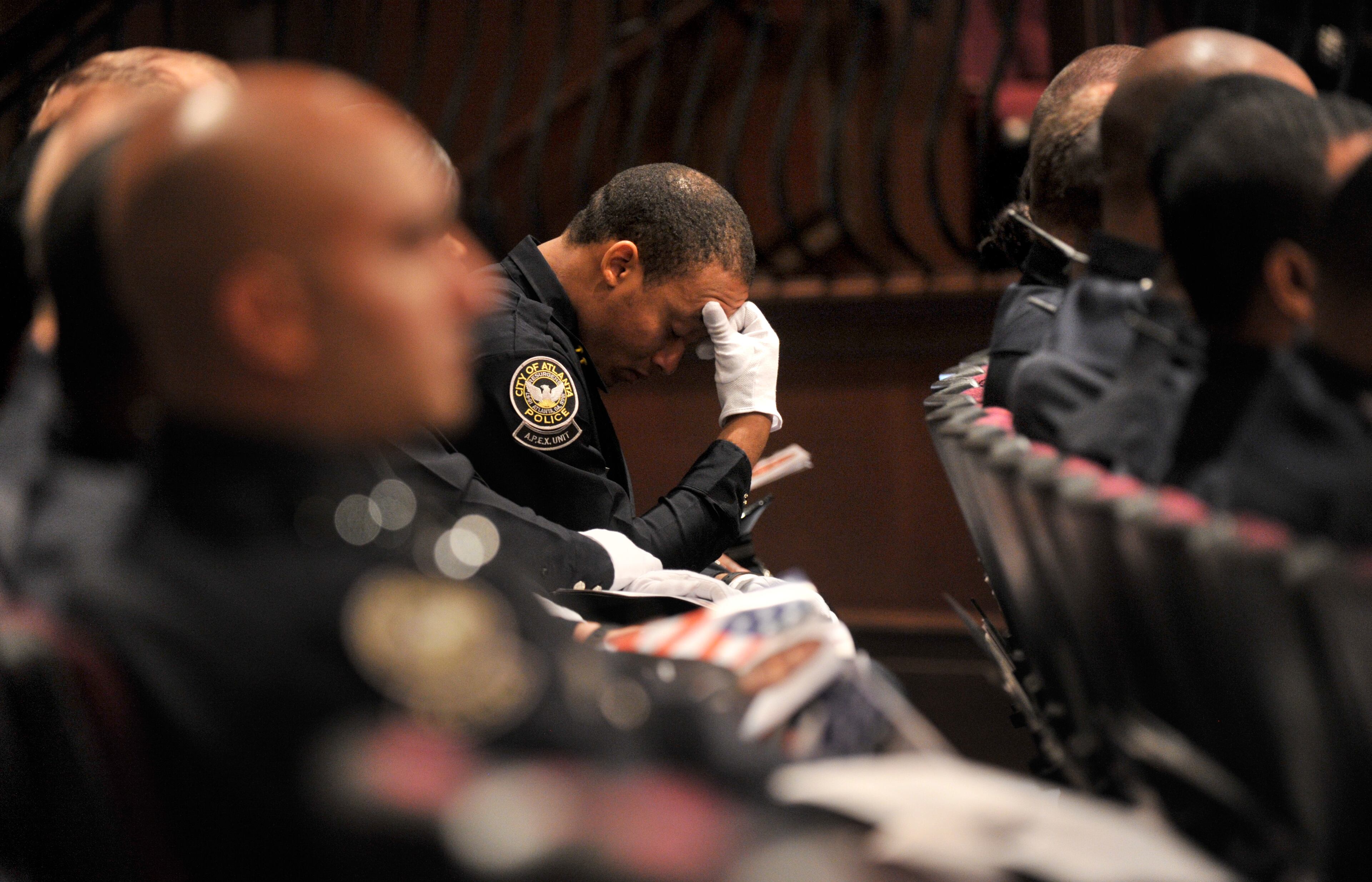 APD officer gets emotional during APD Officer Shawn Smiley's funeral at First Baptist Church of Atlanta on Saturday, November 10, 2012. APD Officer Shawn Smiley was in the passenger seat last weekend when an APD helicopter searching for a missing 9-year-old boy crashed in Atlanta. HYOSUB SHIN / HSHIN@AJC.COM