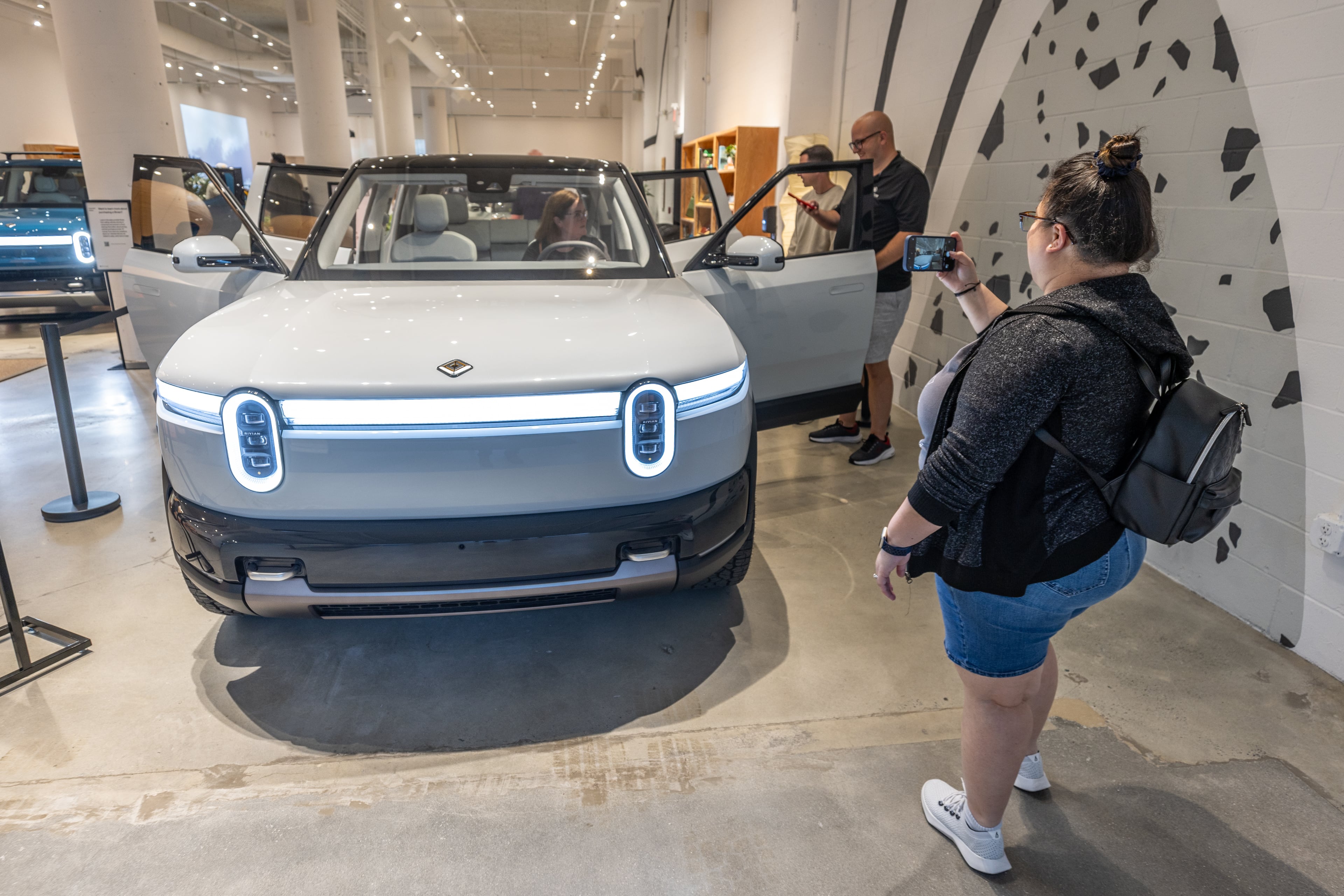 Sabrina Eijan takes a photograph of the new Rivian R2 prototype that will eventually be made in Georgia at the Ponce City Market in Atlanta on April 27, 2024. (Steve Schaefer / AJC)