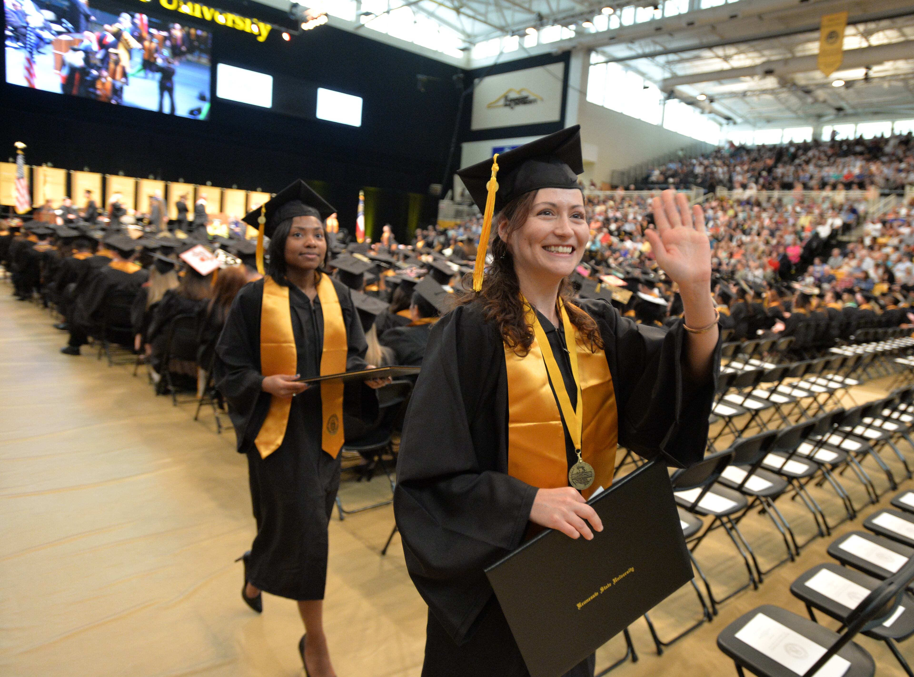 Kennesaw, GA: Nicole Baldwin waves to supporters after receiving her bachelor of science degree at Kennesaw State University commencement Thursday May 14, 2015. More than 2,200 students participated in Kennesaw State University’s four spring Commencement ceremonies at the Convocation Center on May 13 and 14. Tony Award-winning Broadway and film director Kenny Leon was the speaker during the morning commencement which included, College of the Arts, College of Education, College of Health and Human Services and University College. BRANT SANDERLIN/BSANDERLIN@AJC.COM