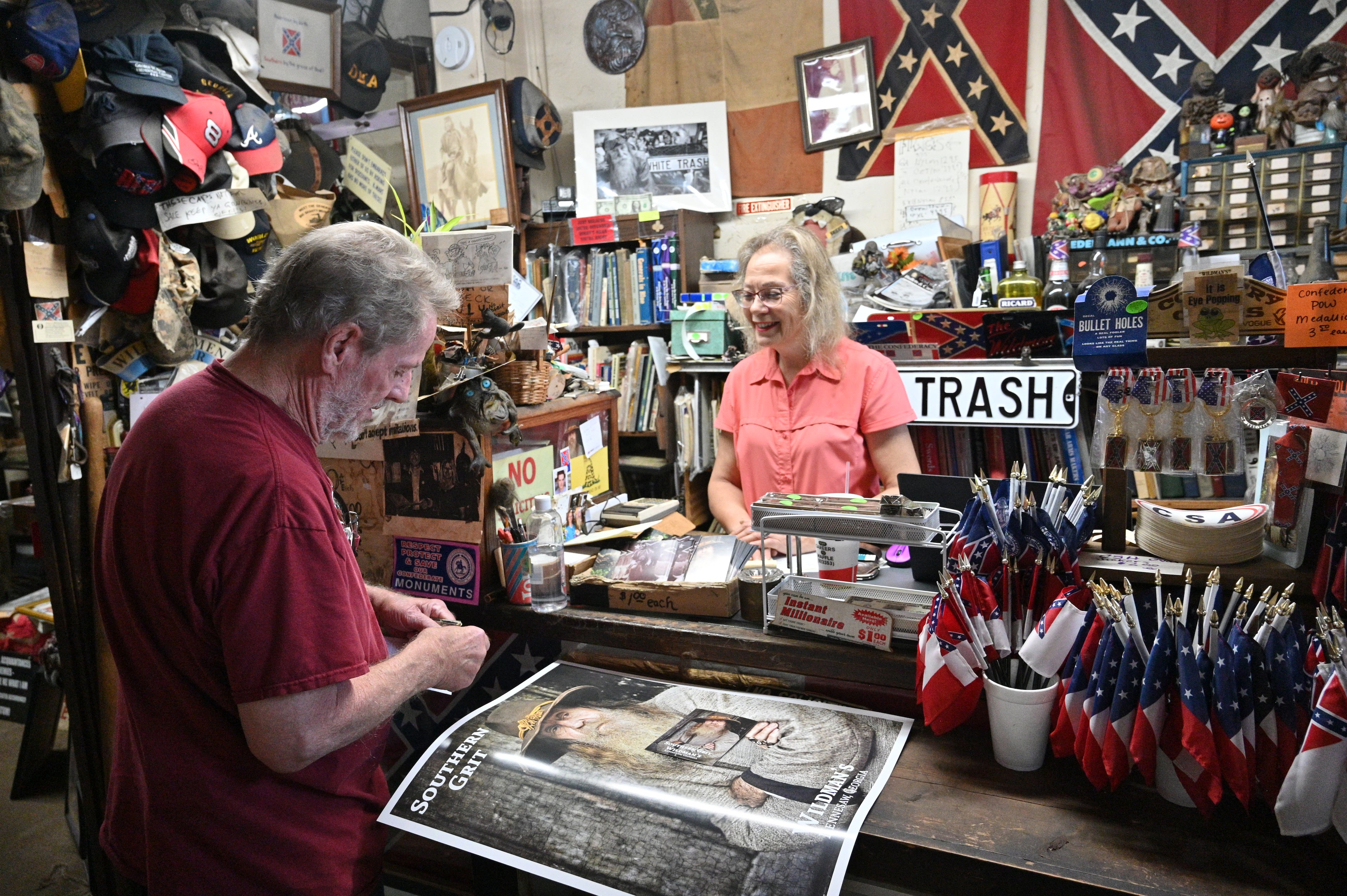 Marjorie Lyon (right), the new owner of Wildman's Civil War Surplus, helps longtime customer Mickey Magruder in Kennesaw. In taking control of previous owner Dent Myers’ assets and real estate, a judge said Lyon breached the terms of the trust. (Hyosub Shin/AJC 2022)