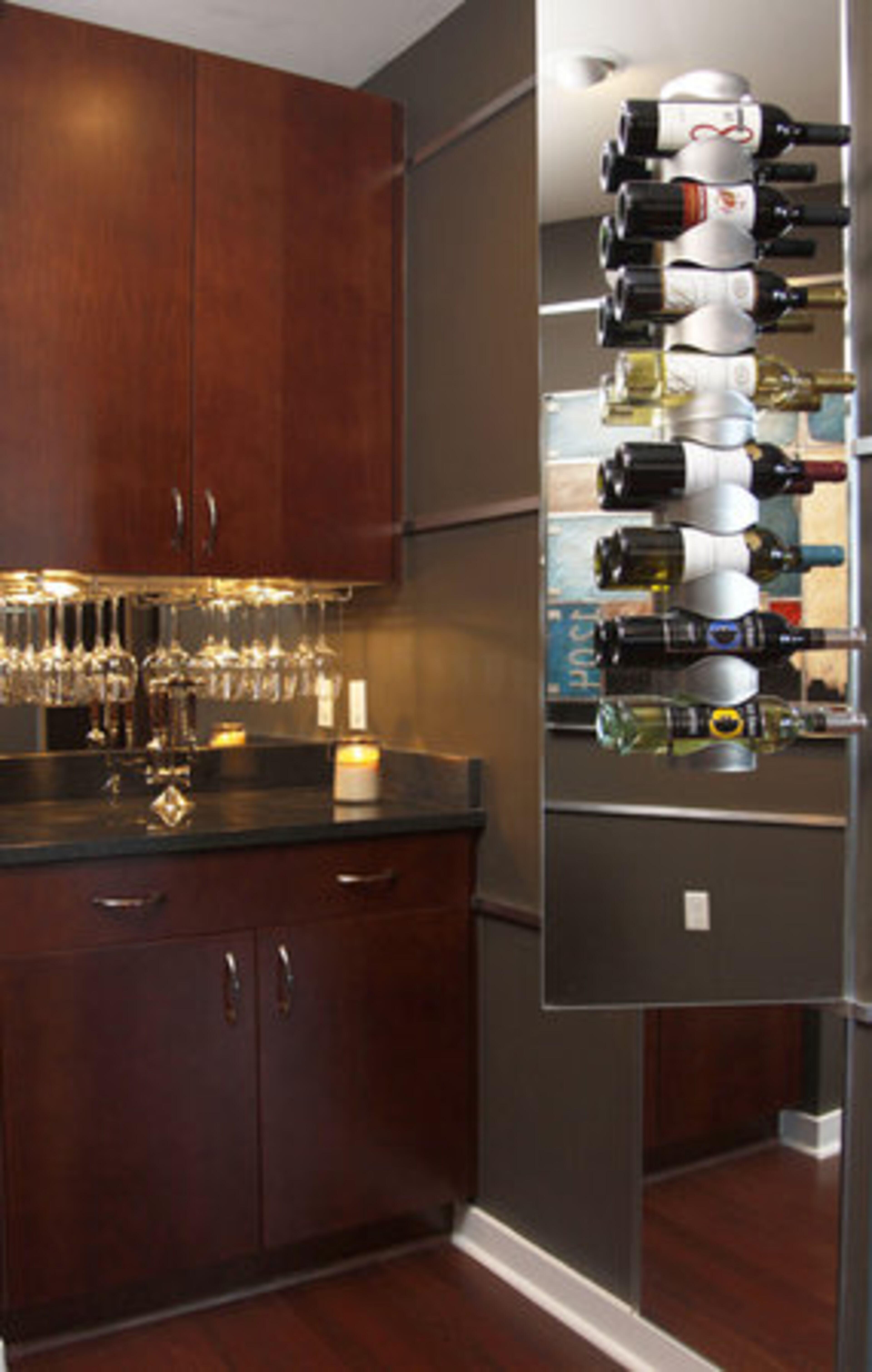 "With this particular home I had to be aware and cautious of the limited space, therefore, to make this home 'work' I had to make the design not only appealing but functional and space-saving," explains Strahl. The bar/wine storage area near the entry way illustrates his approach. A wine rack is mounted on a glass door that also conceals a utility box.