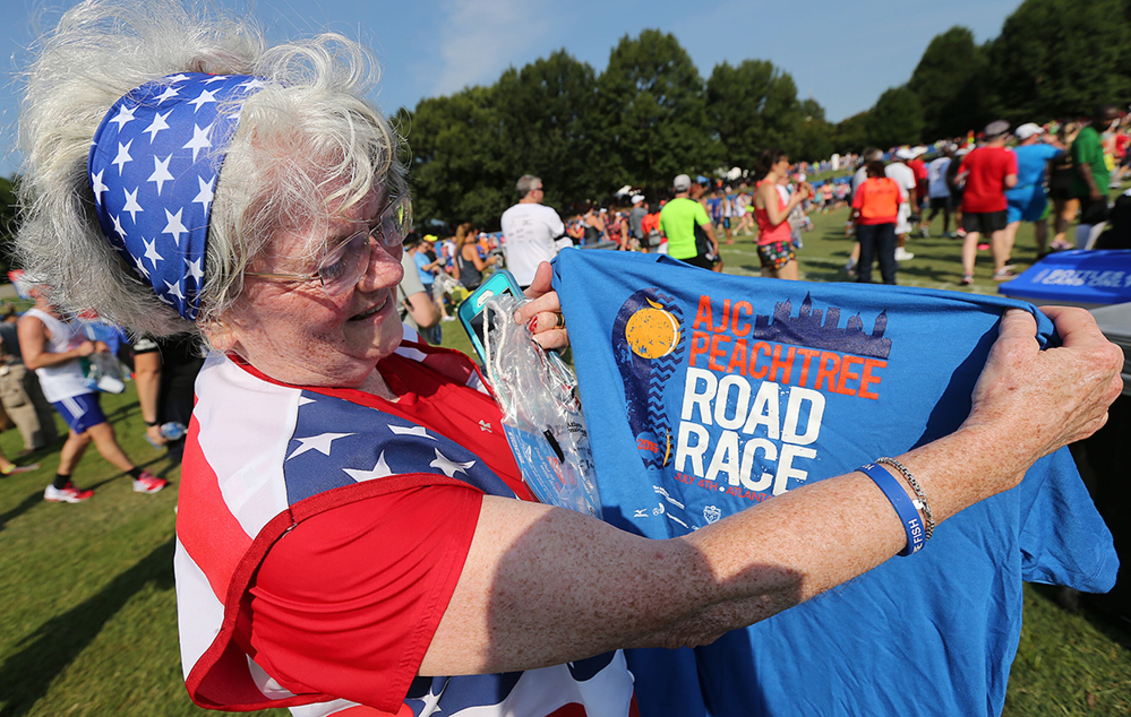 Candi Sprague, of Sandy Springs, checks out her shirt after finishing the 47th AJC Peachtree Road Race at Piedmont Park on Monday, July 4, 2016, in Atlanta.
