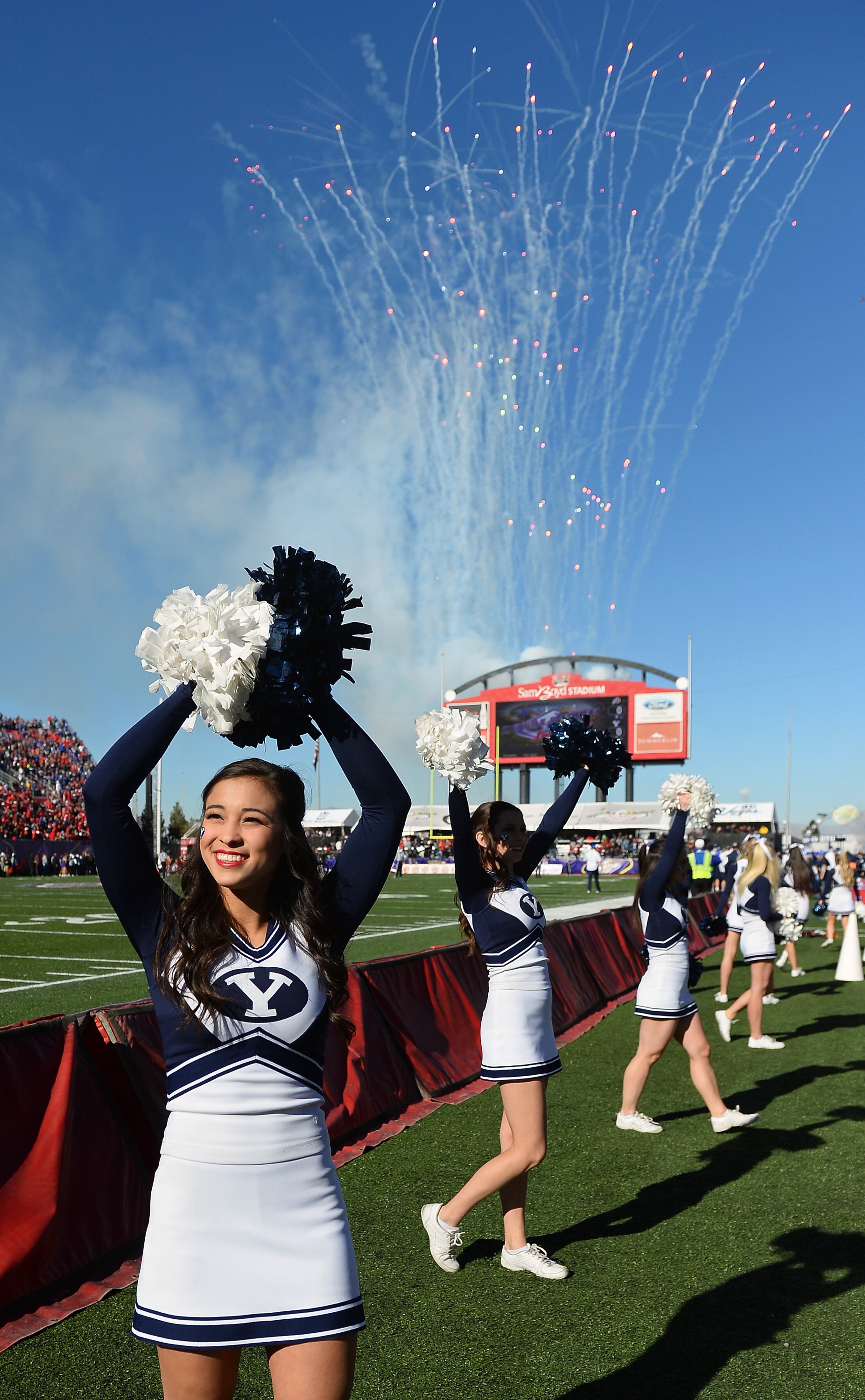 LAS VEGAS, NV - DECEMBER 19: Brigham Young Cougars cheerleaders perform as fireworks explode at the beginning of the team's game against the Utah Utes in the Royal Purple Las Vegas Bowl at Sam Boyd Stadium on December 19, 2015 in Las Vegas, Nevada. Utah won 35-28. (Photo by Ethan Miller/Getty Images)