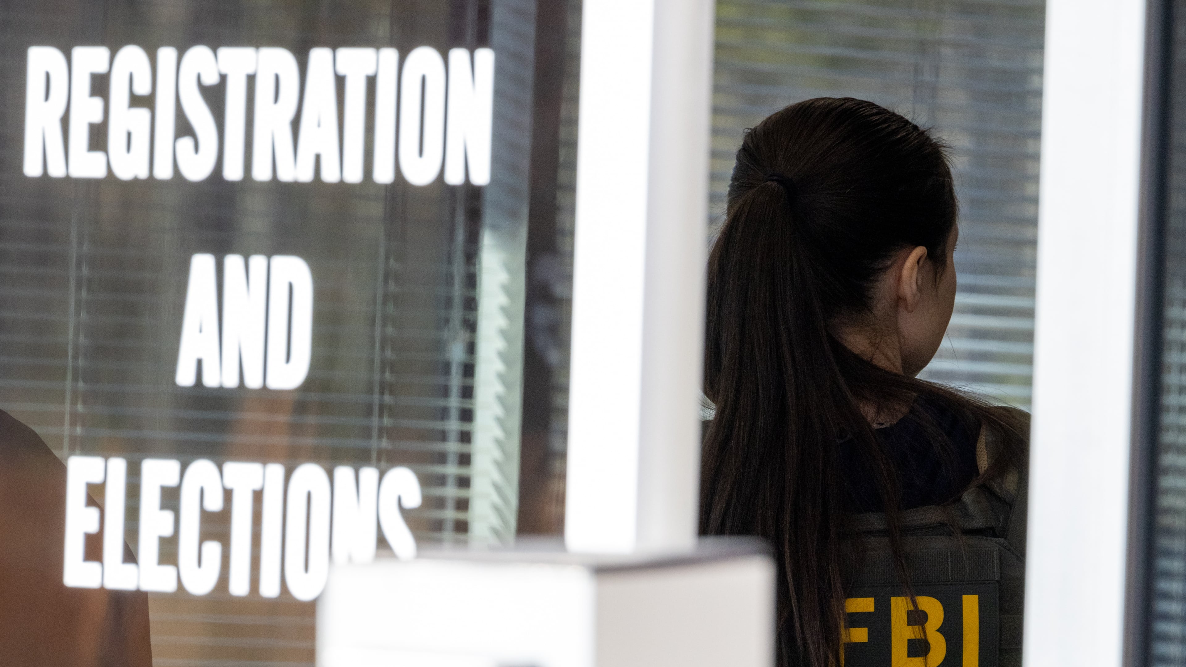 An FBI agent stands inside the entrance to the Fulton County Election Hub and Operation Center in Union City in January. (Arvin Temkar/AJC)