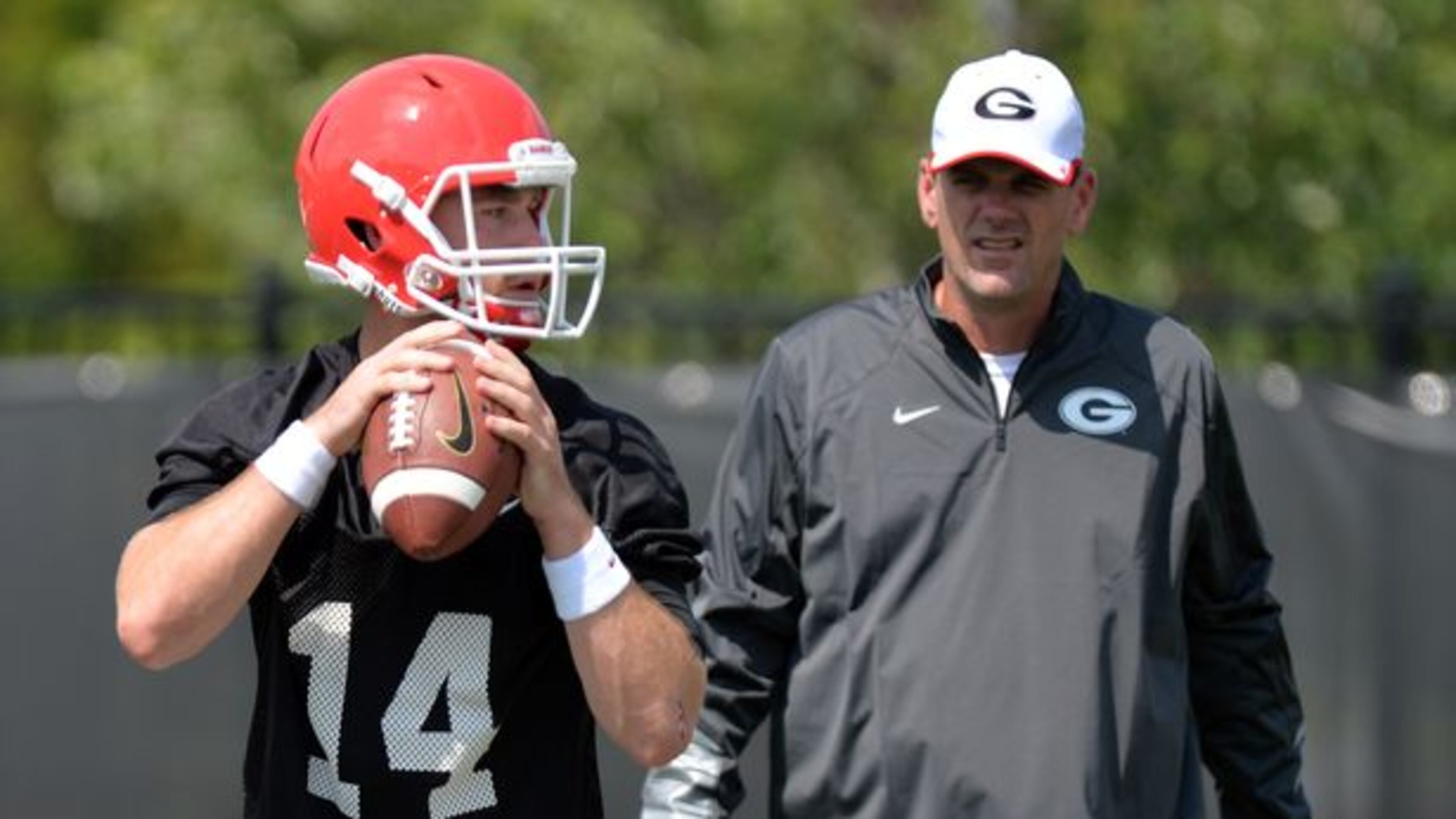 Mike Bobo, shown with Hutson Mason, is interviewing for the Colorado State job. (Brant Sanderlin/AJC photo)