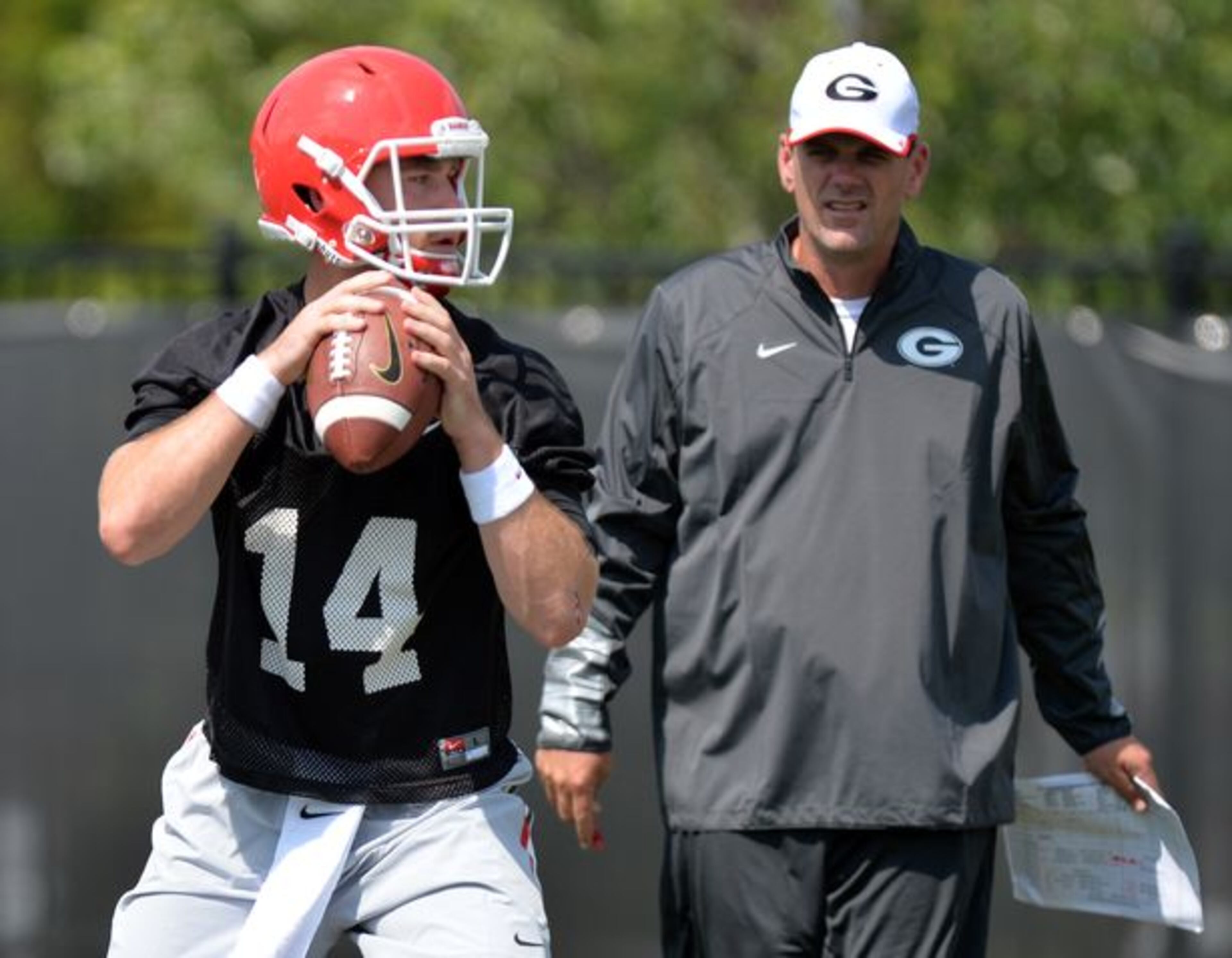 Mike Bobo, shown with Hutson Mason, is interviewing for the Colorado State job. (Brant Sanderlin/AJC photo)