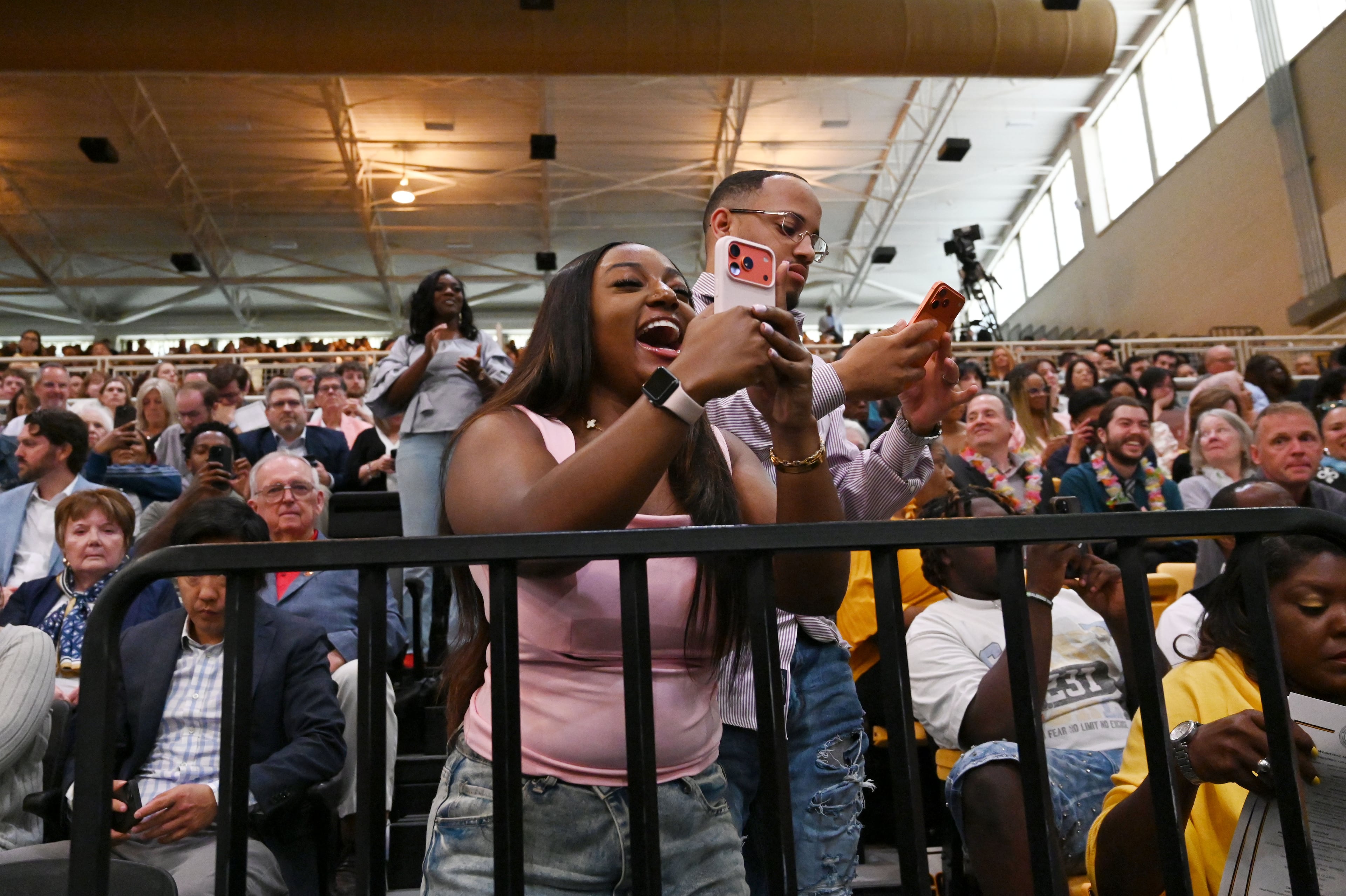Family and friends try their best to get a photo of their graduate. (Hyosub Shin/AJC)