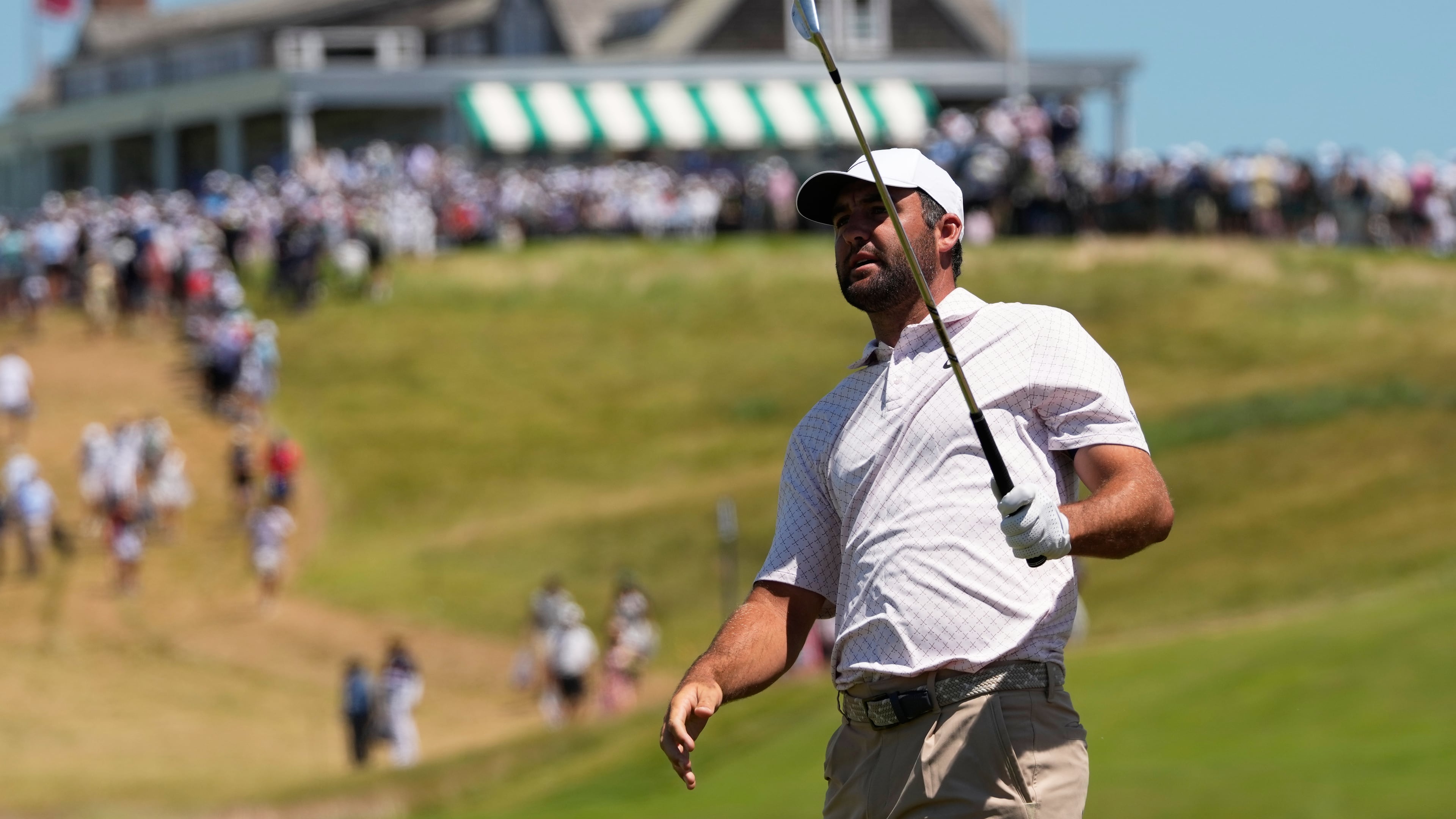 Scottie Scheffler watches his shot on the first hole during the third round of the U.S. Open golf tournament at Shinnecock Hills Golf Club in Southampton, N.Y., Saturday, June 20, 2026.(AP Photo/David J. Phillip)