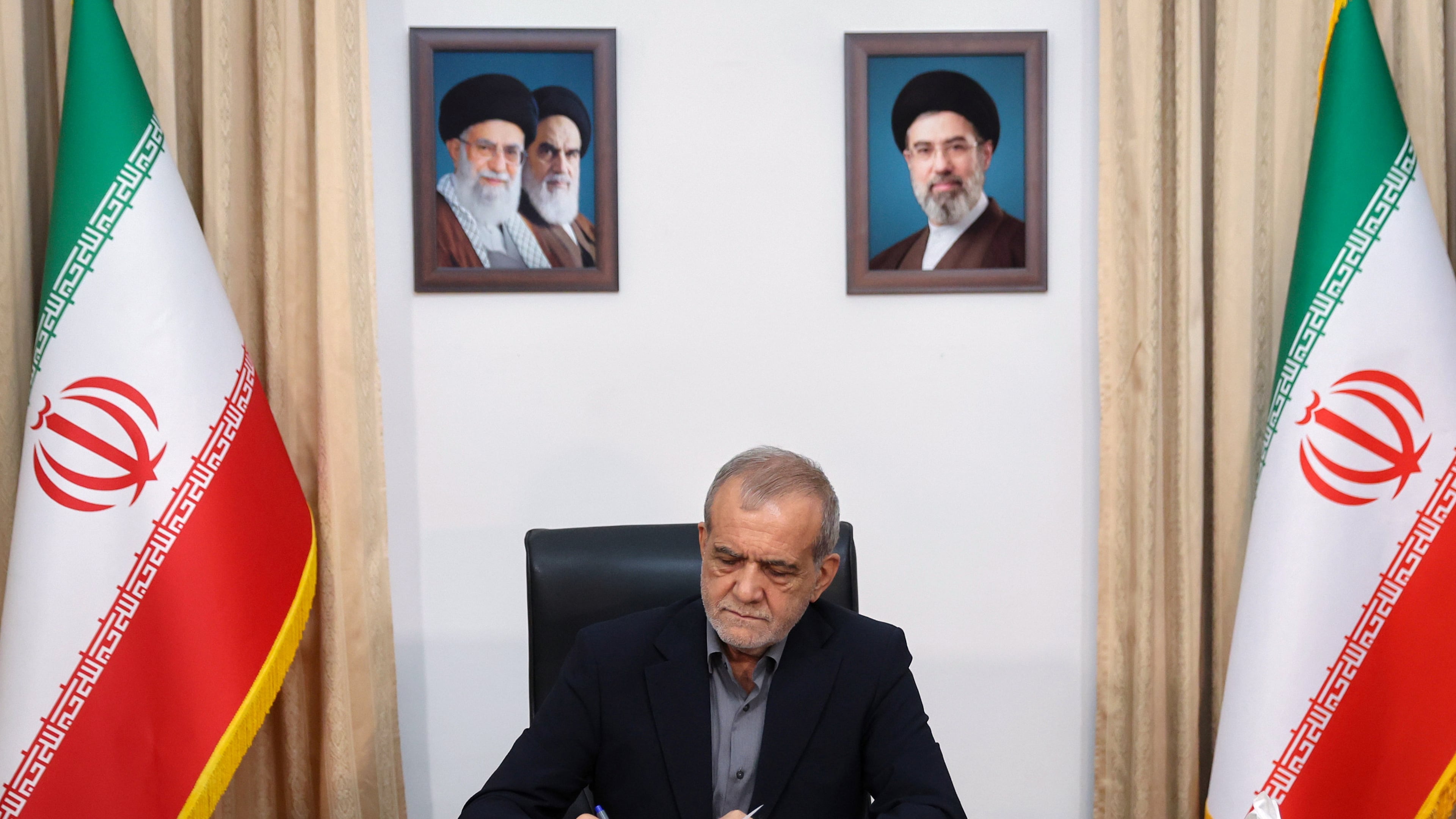 In this photo realised by Iran Presidentcy Office, Iranian President Masoud Pezeshkian signs a memorandum of understanding already signed by U.S. President Donald Trump aimed at ending the war and launching negotiations on a broader agreement, in Tehran, Iran, early Thursday, June 18, 2026. (Iranian Presidency Office via AP)