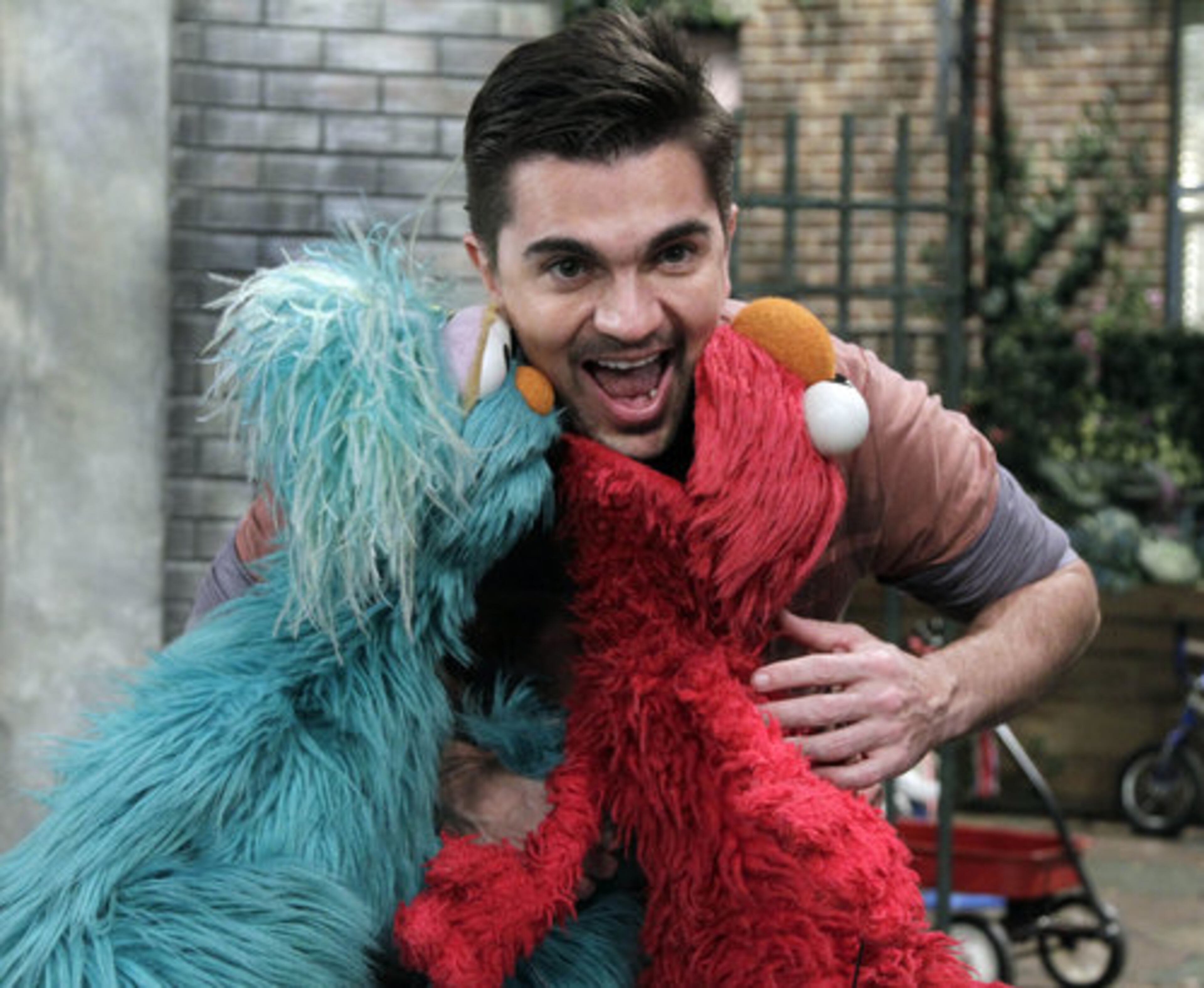 THIS IS WHAT HAPPENS WHEN YOU DON'T TICKLE ELMO: Colombian musician Juanes poses for photos with Rosita, left, and Elmo on the set of "Sesame Street," during the taping of his appearance on the show in New York, Monday, April 11, 2011.
