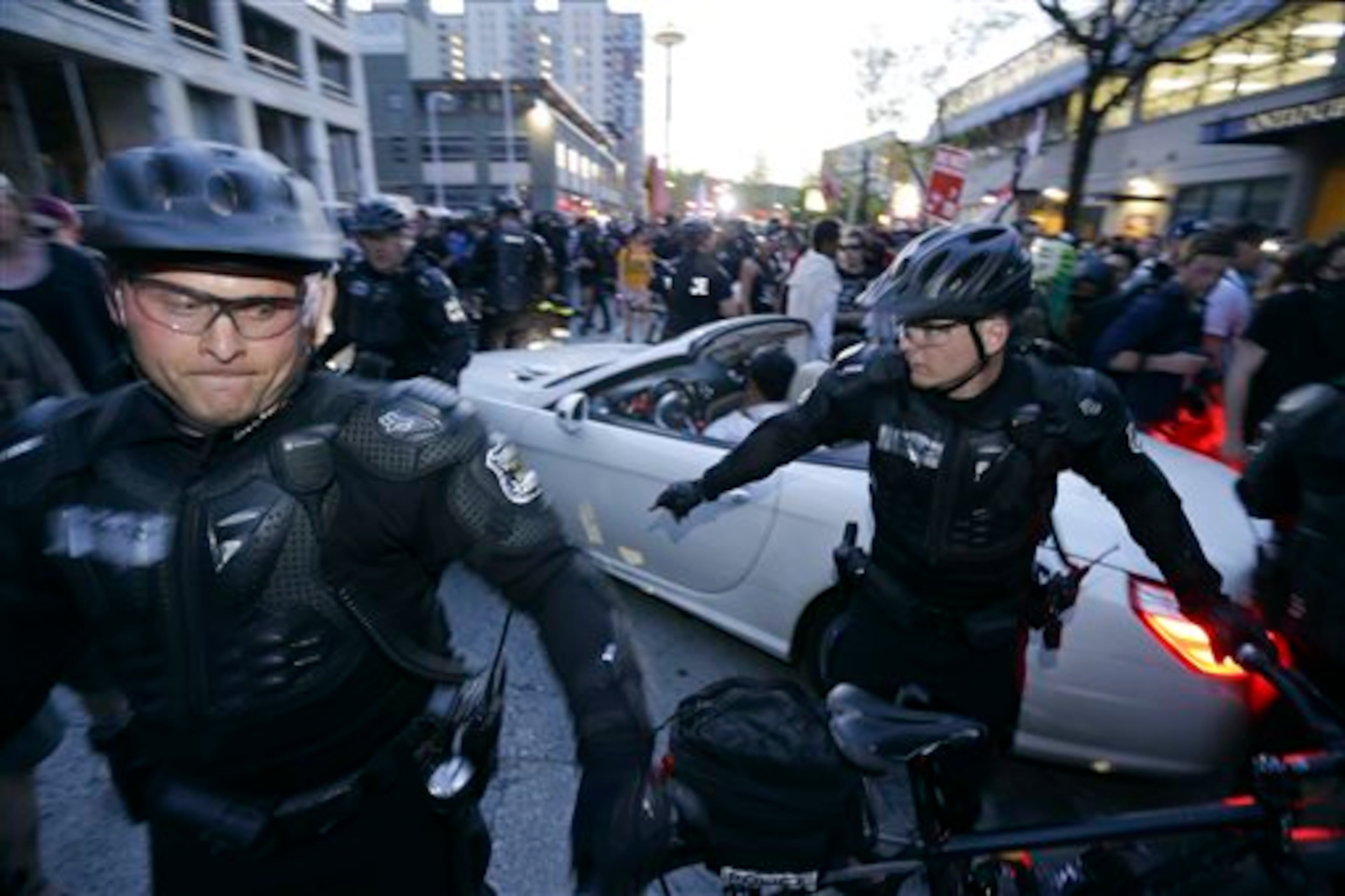 A car makes its way through protesters and police during May Day activities Thursday, May 1, 2014 in Seattle. Police have made several arrests and fired pepper spray as anti-capitalist marchers meandered through Seattle several hours after hundreds of peaceful demonstrators took part in a May Day march in support of immigrant rights and a boost in the minimum wage. (AP Photo/Ted S. Warren)
