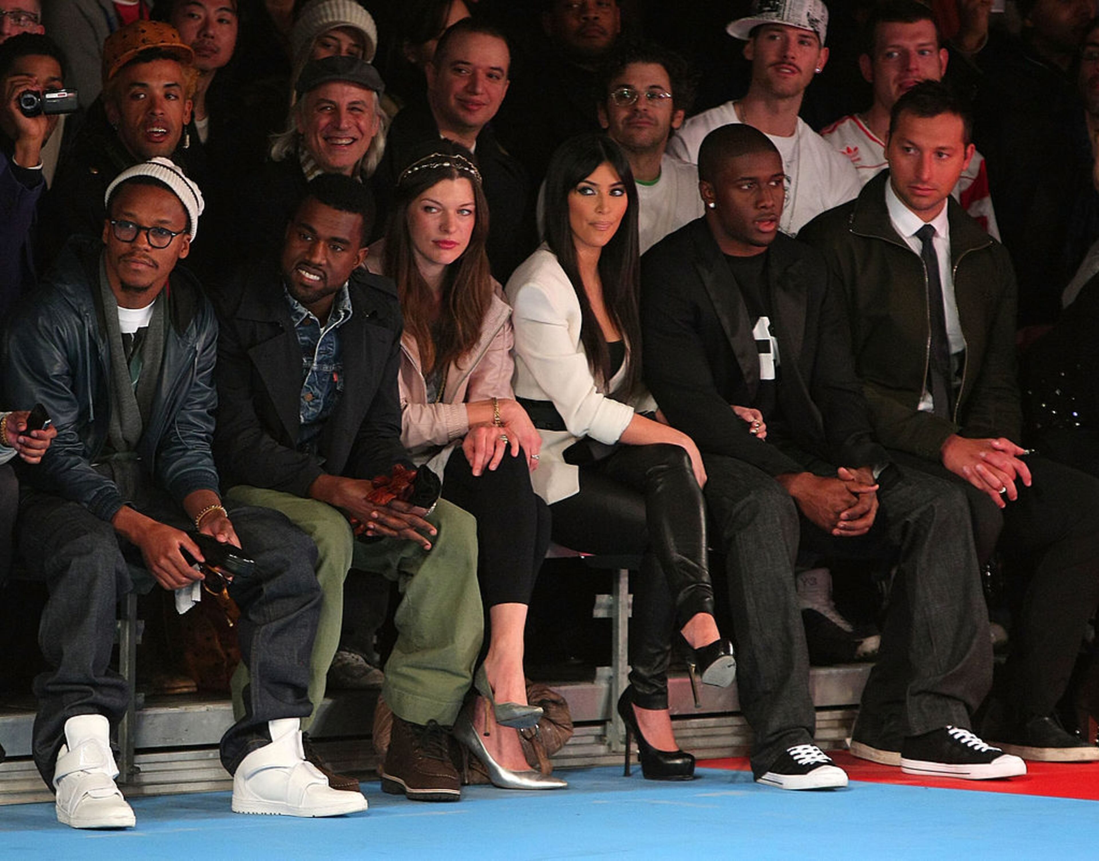 NEW YORK - FEBRUARY 15: (L-R) Lupe Fiasco, Kanye West, Milla Jovovich, Kim Kardashian, Reggie Bush and Ian Thorpe attend the Y-3 Autumn/Winter 2009-10 fashion show during Mercedes-Benz Fashion Week at Pier 40 on February 15, 2009 in New York City. (Photo by Andrew H. Walker/Getty Images for Y-3)