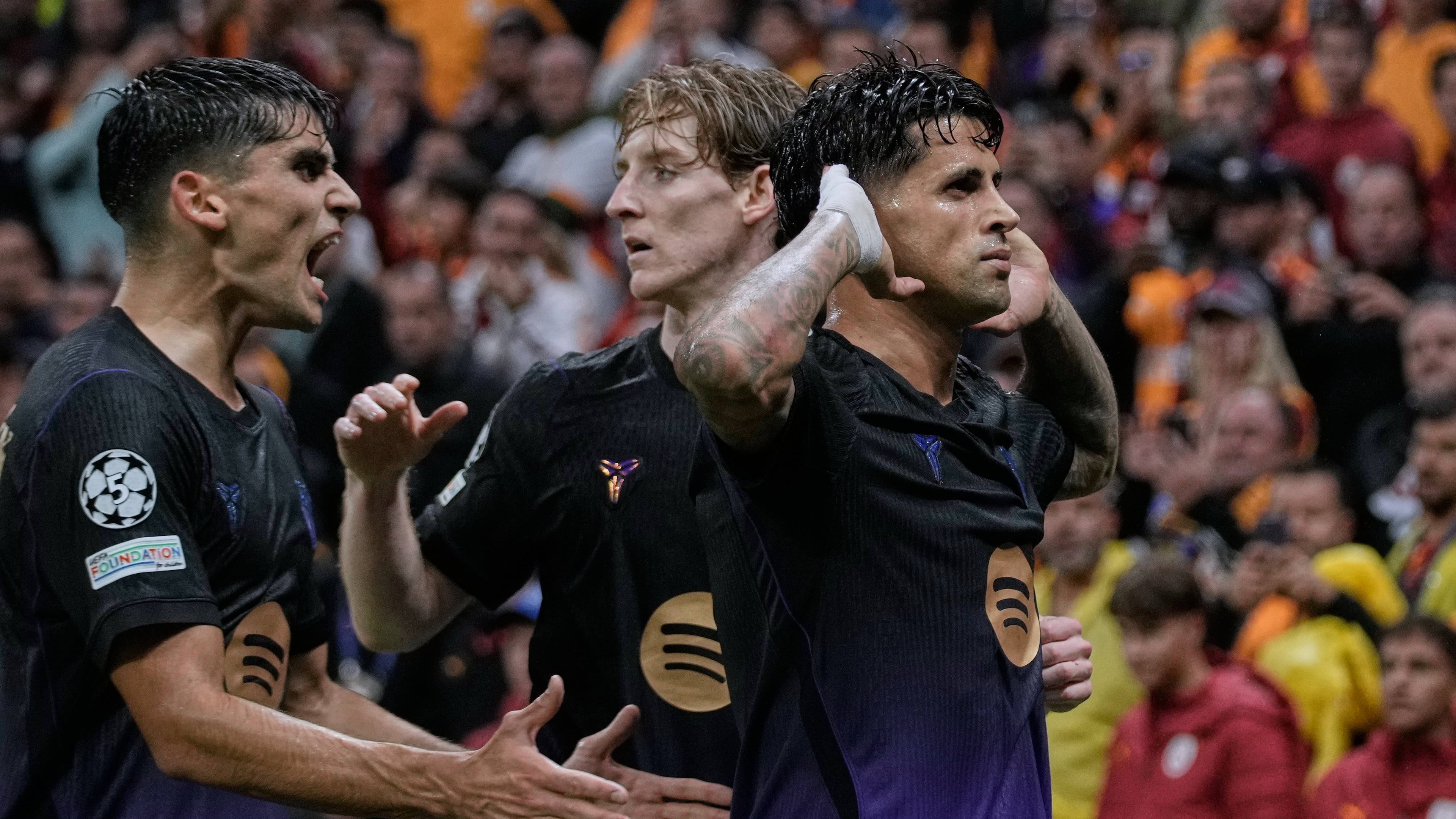 Barcelona's Joao Cancelo, right, celebrates with teammates after scoring his side's first goal during the Champions League opening phase soccer match between Galatasaray and Barcelona in Istanbul, Turkey, Tuesday, Oct. 13, 2026. (AP Photo/Khalil Hamra)