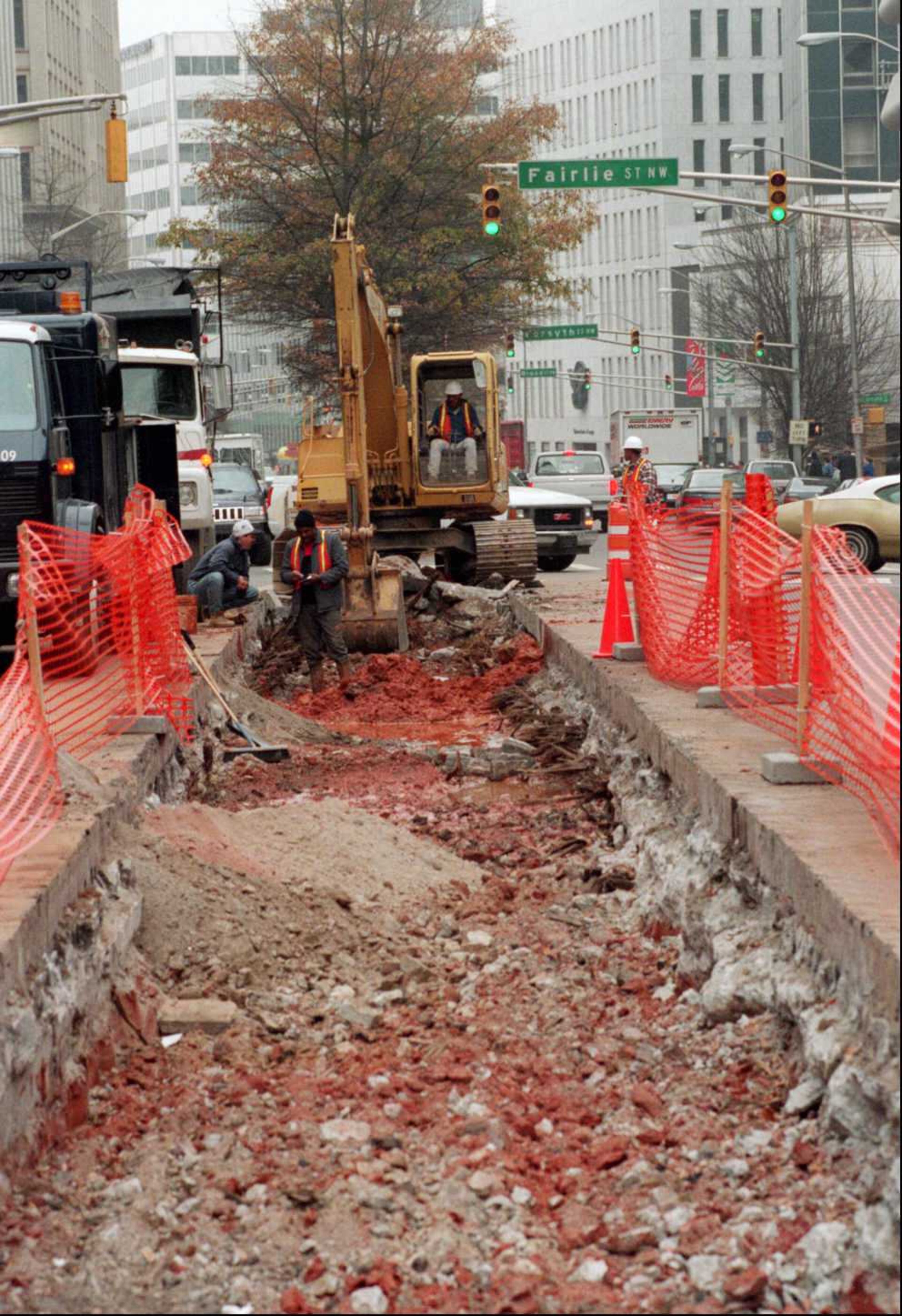 Workers tear up the middle of Marietta Street on Wednesday, where old railroad ties from Atlanta's horse-drawn trolleys were uncovered in December 1995.